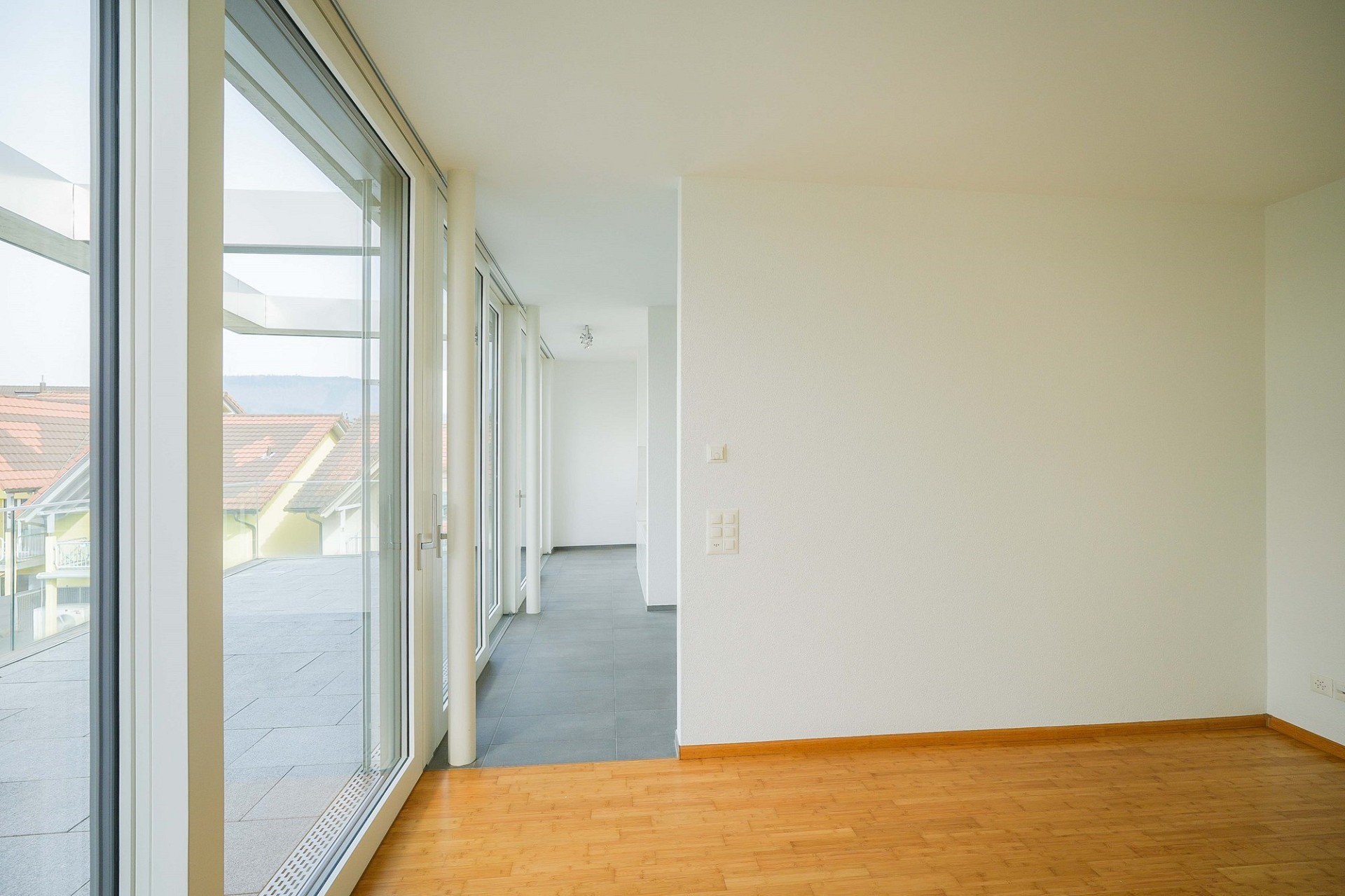 Heller Wohnbereich mit großer Fensterfront und Zugang zur Terrasse