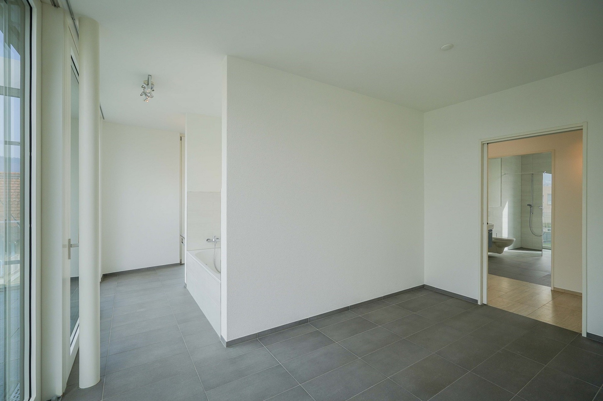 Heller leerer Innenraum mit Blick ins Bad