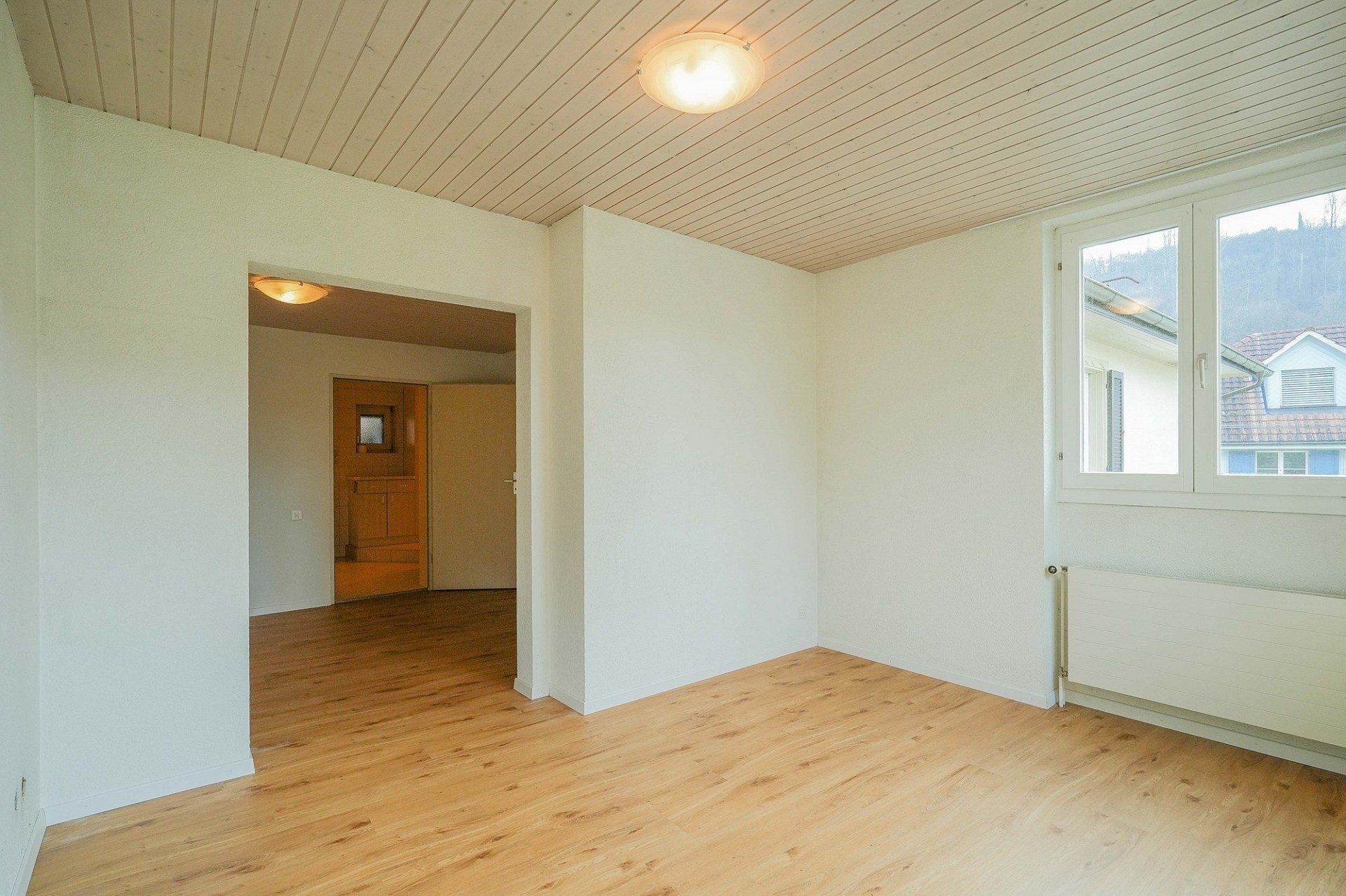 Helles leerstehendes Zimmer mit Holzdecke