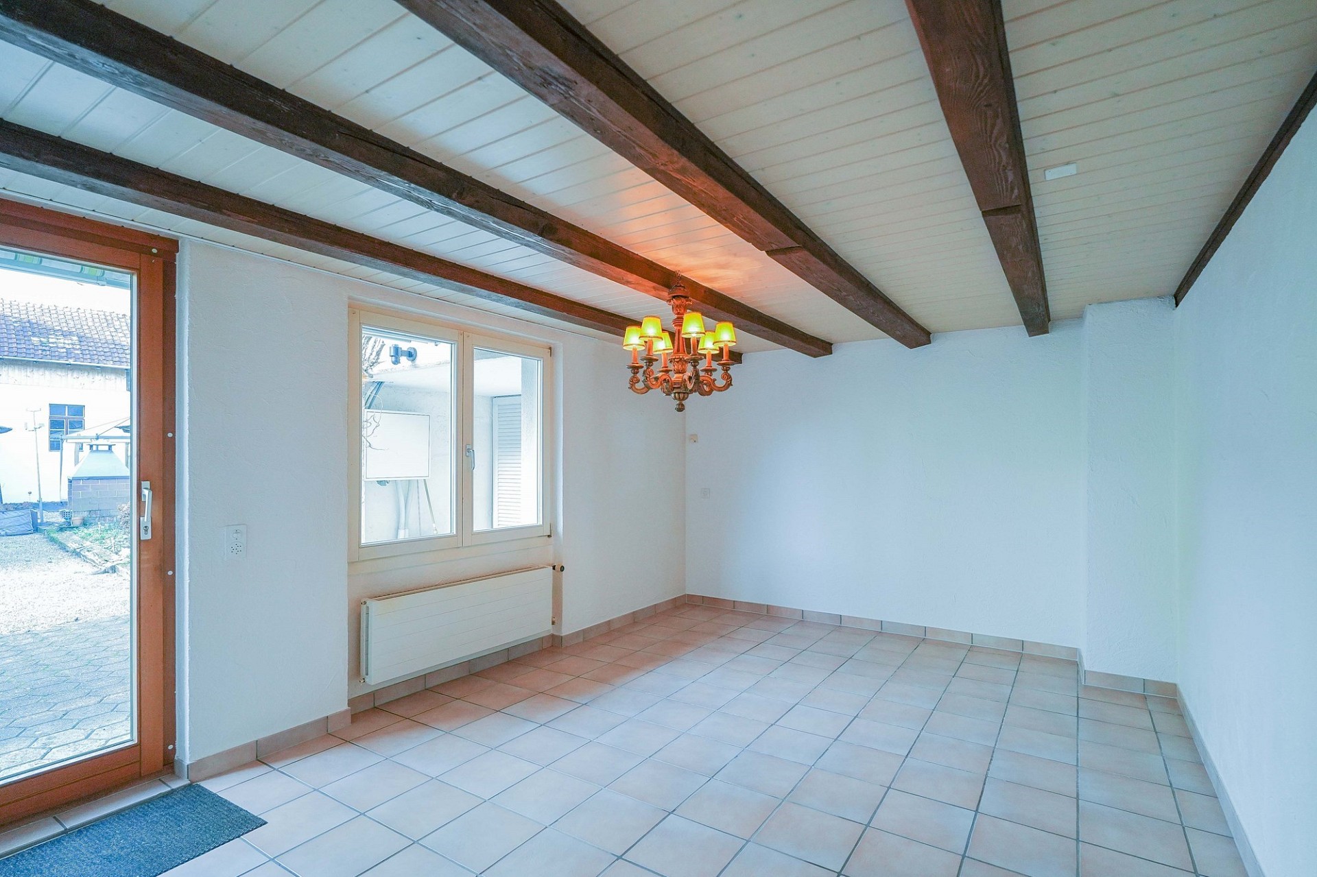 Heller Raum mit Holzbalken und Terrakottafliesen