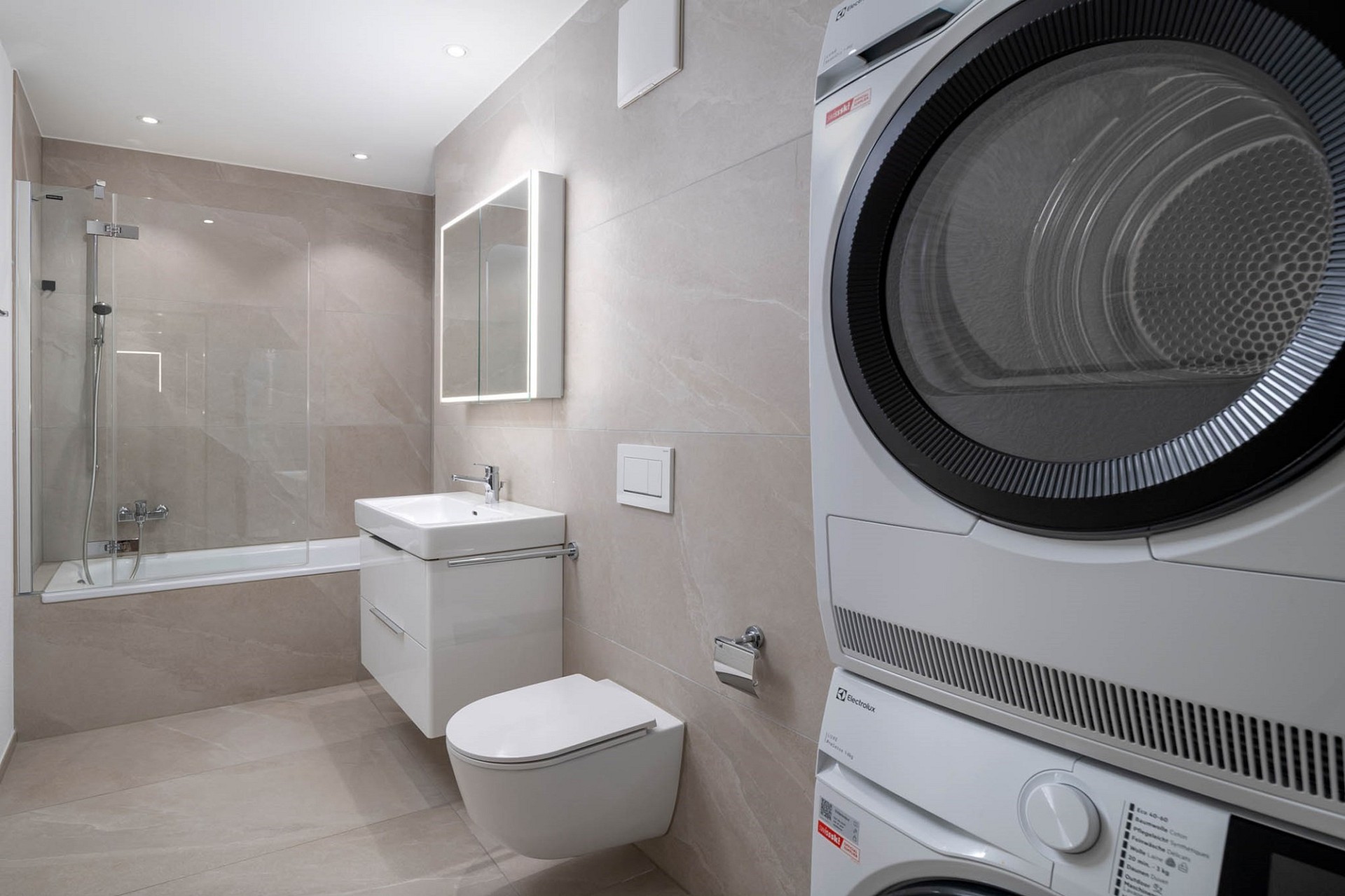 Modernes Bad mit Waschtisch, WC, Dusche und Wäscheturm