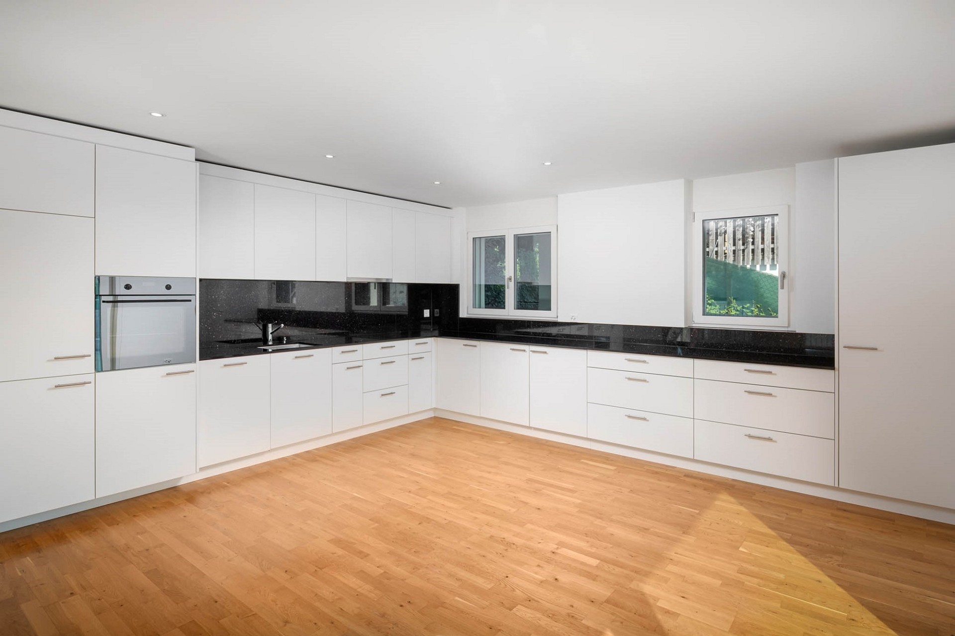 Moderne weiße Küche mit Holzparkett