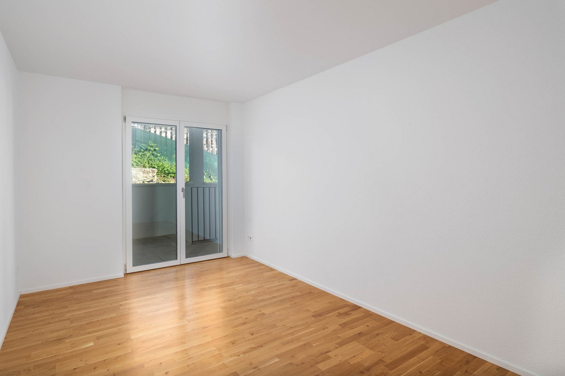 Heller leerer Raum mit Balkon-/Terrassentür