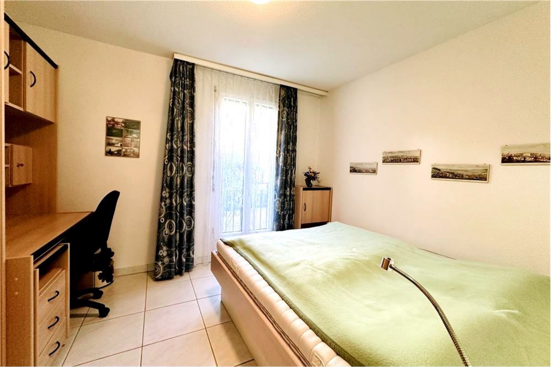 Helles Schlafzimmer mit Schreibtisch und Fenster