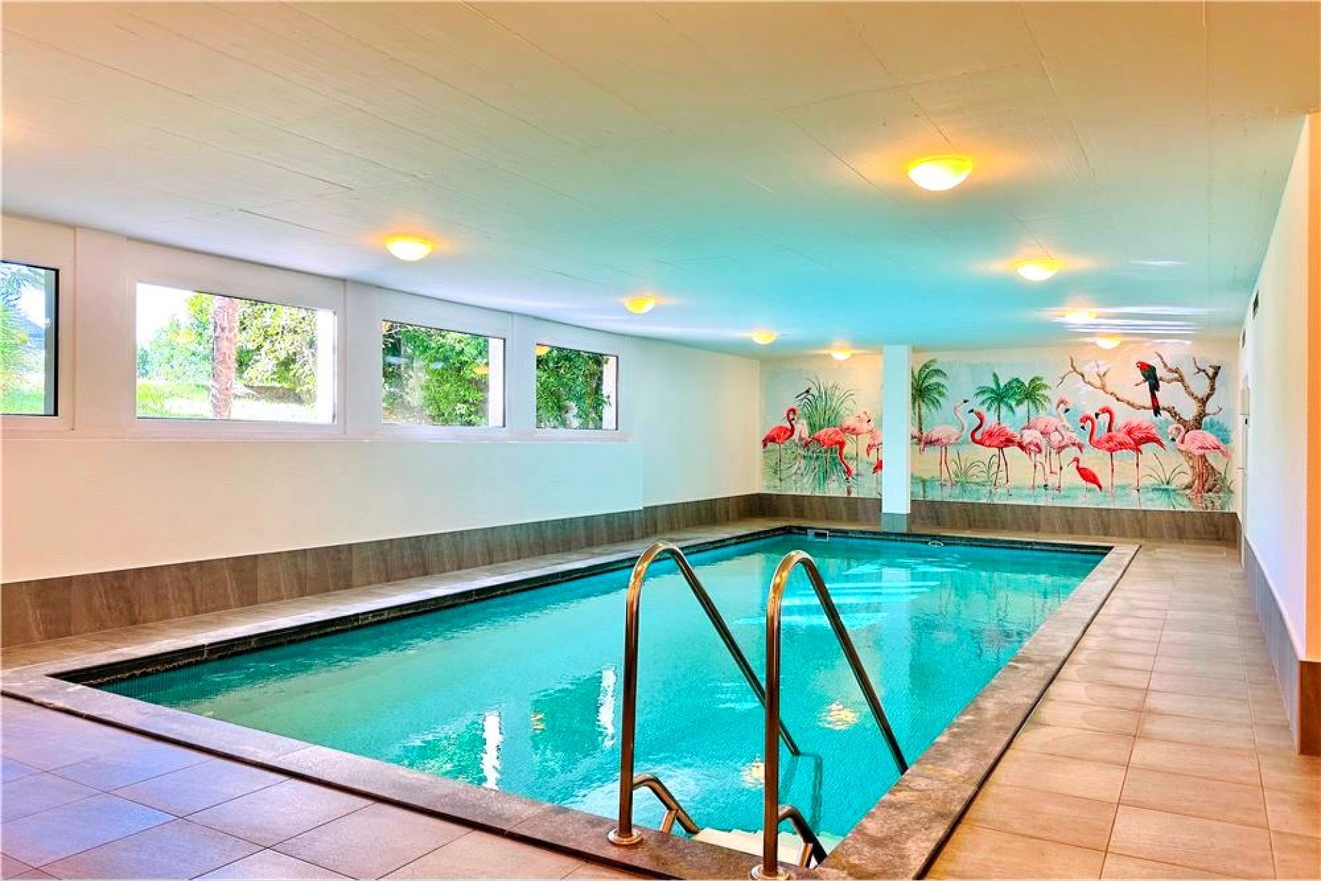Indoor-Schwimmbad mit Palmenwandmalerei