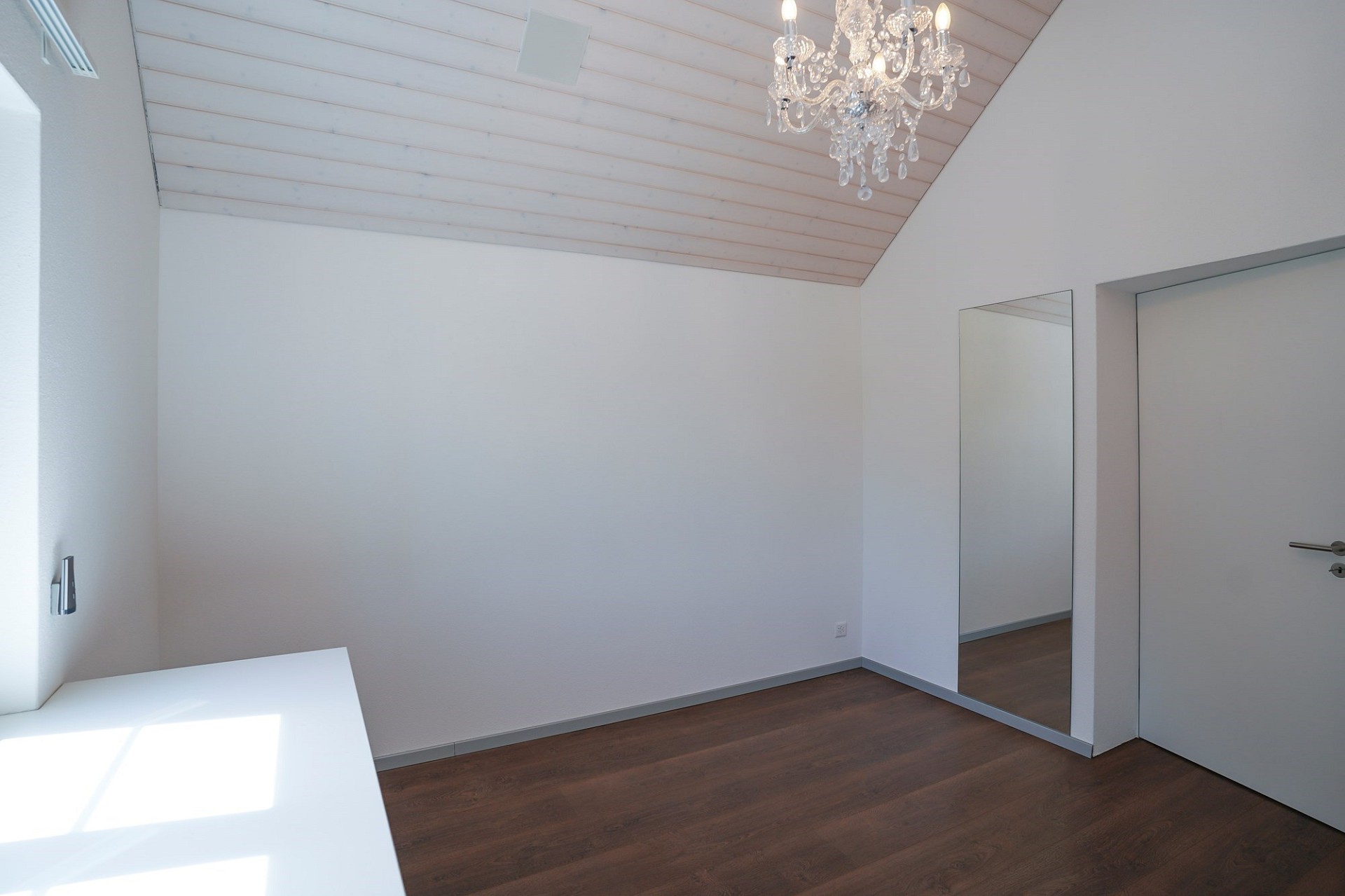 Heller Dachraum mit Holzdecke und Kronleuchter