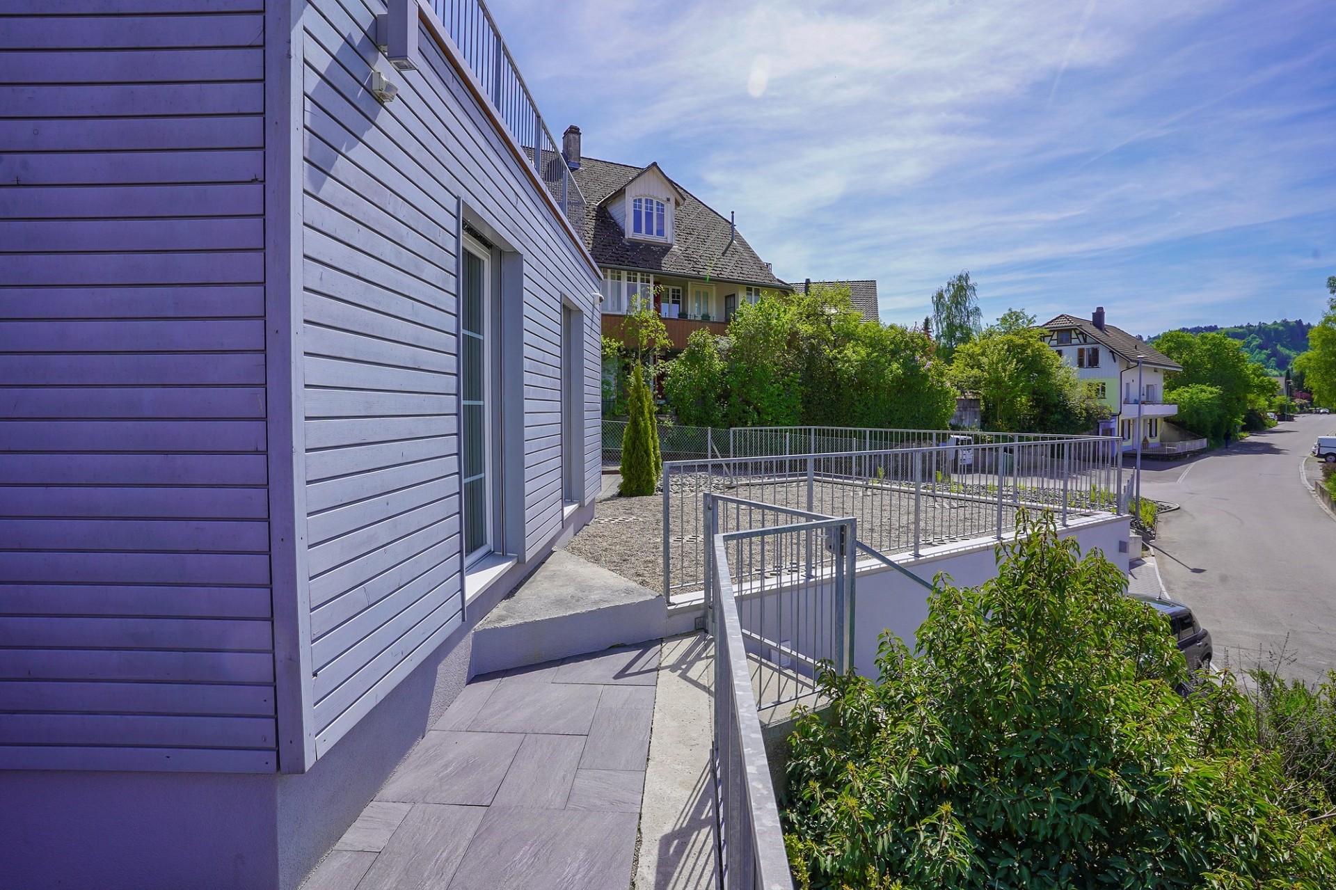 Moderne Außenansicht mit Terrasse und Straßenblick