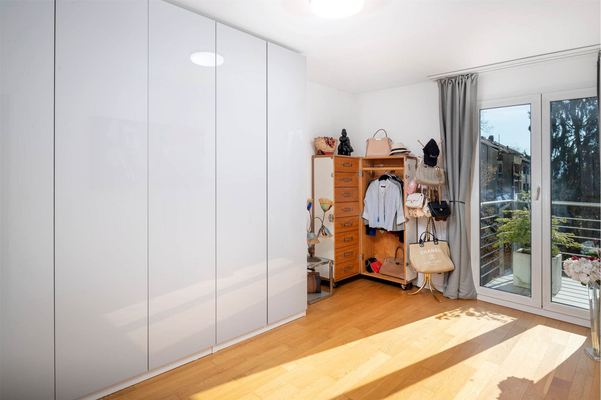 Helles Schlafzimmer mit Ankleidebereich und Balkonzugang