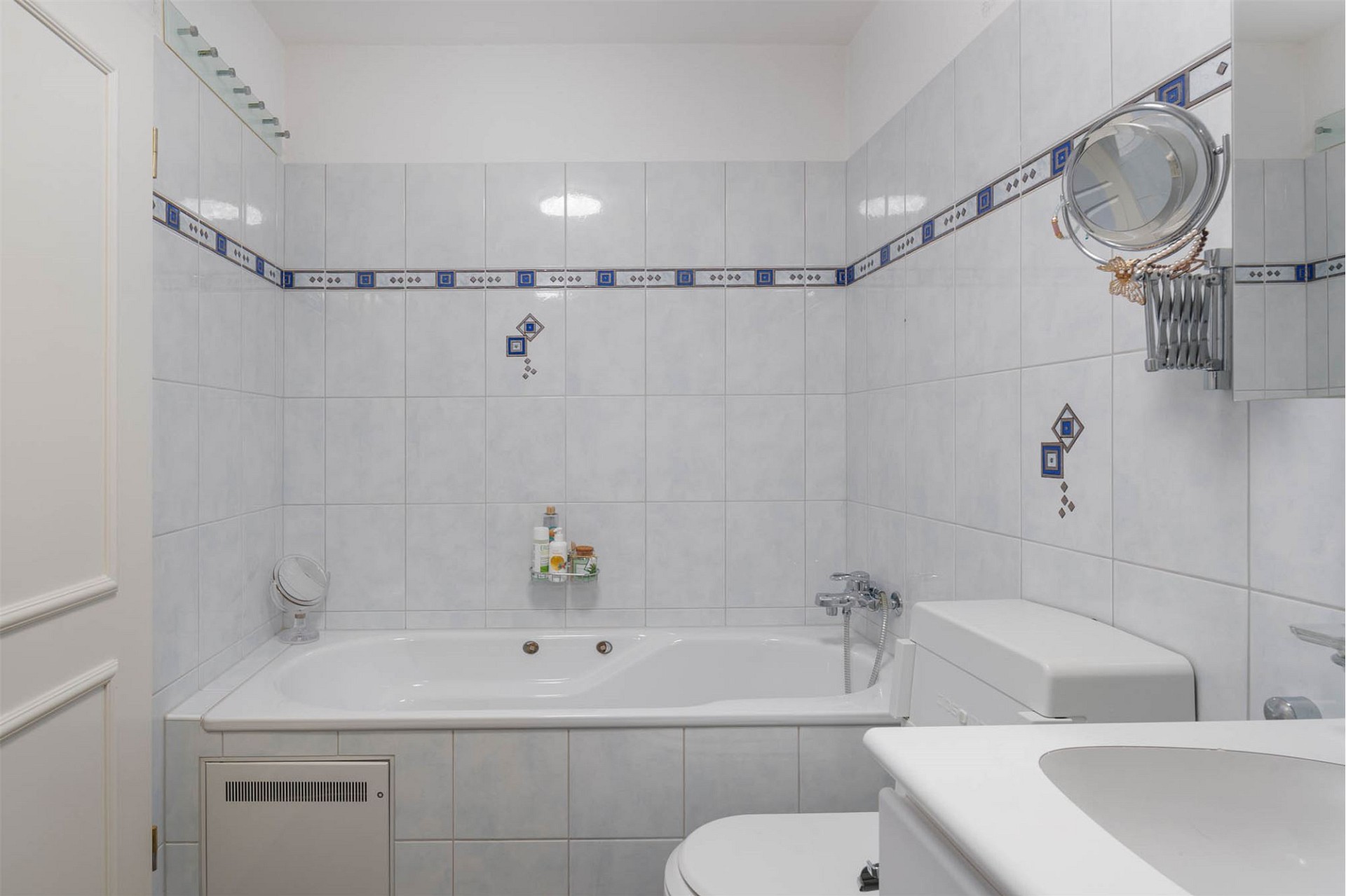 Helles Badezimmer mit Badewanne und weißen Fliesen