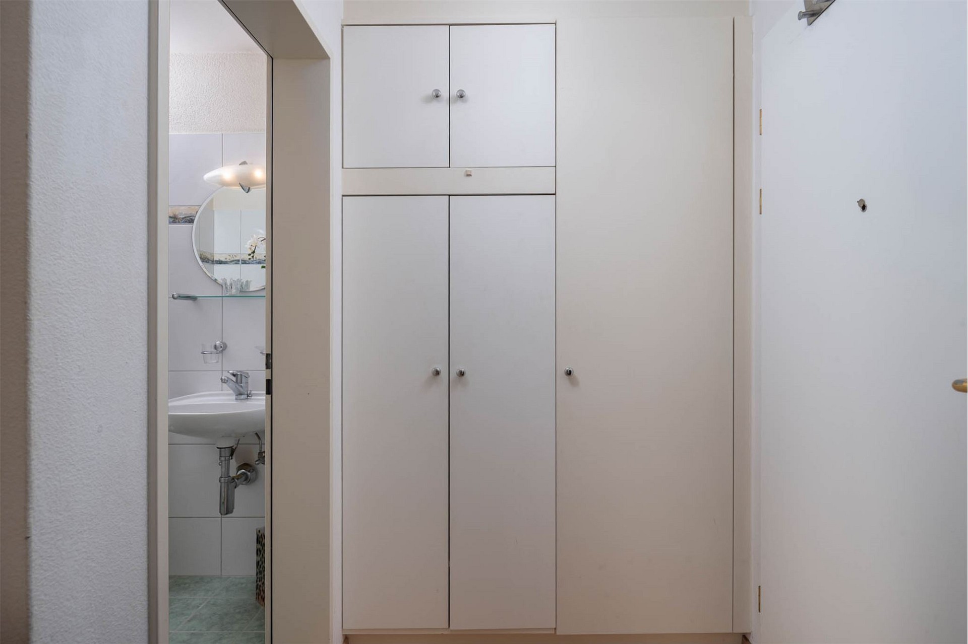 Flur mit Einbauschrank und Blick ins Bad
