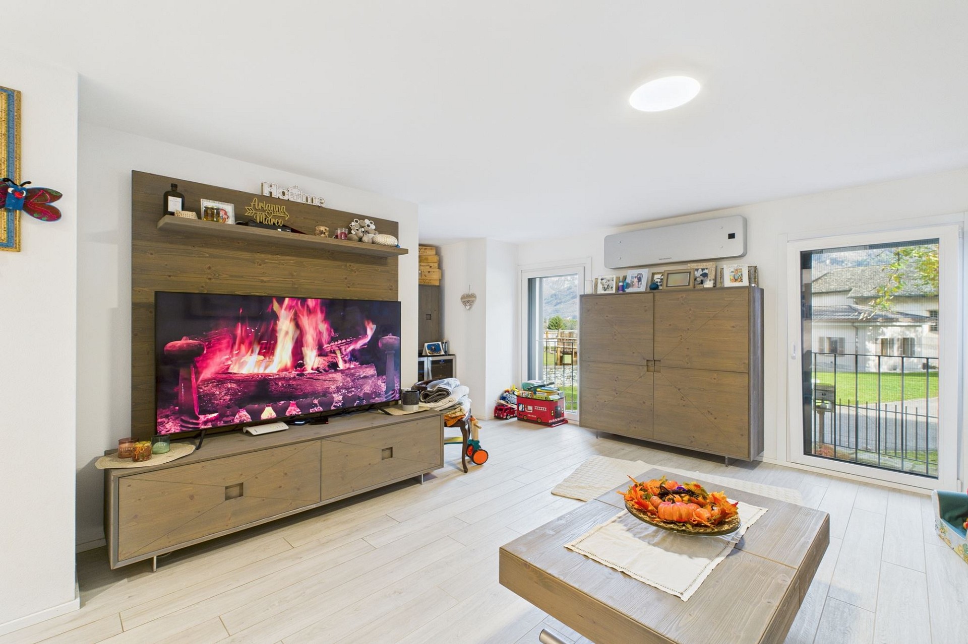 Helles Wohnzimmer mit TV und Holzmöbeln