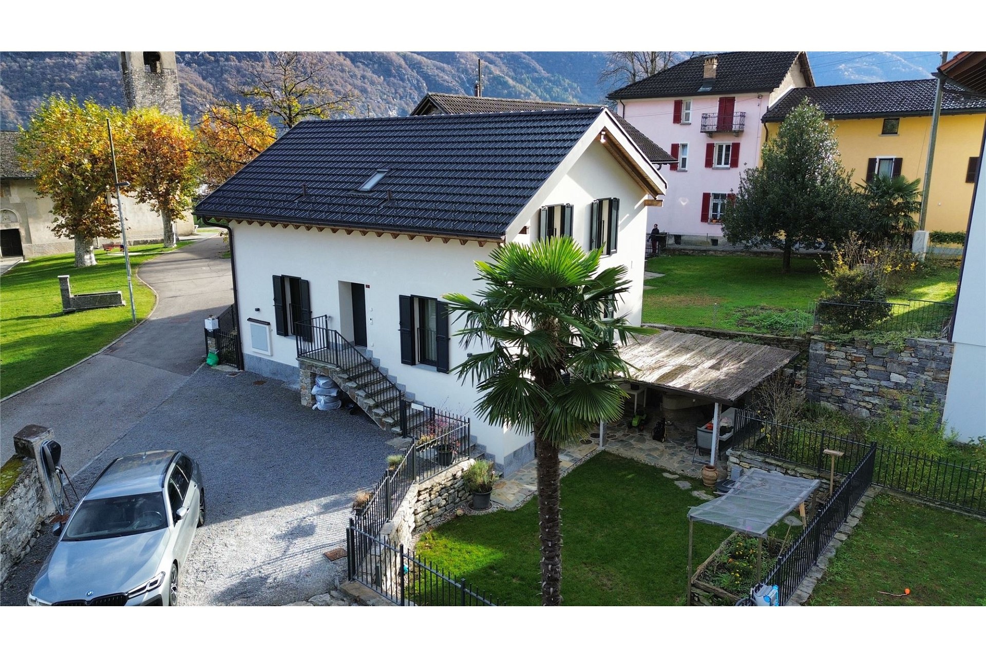 Außenansicht eines Einfamilienhauses mit Garten und Bergkulisse