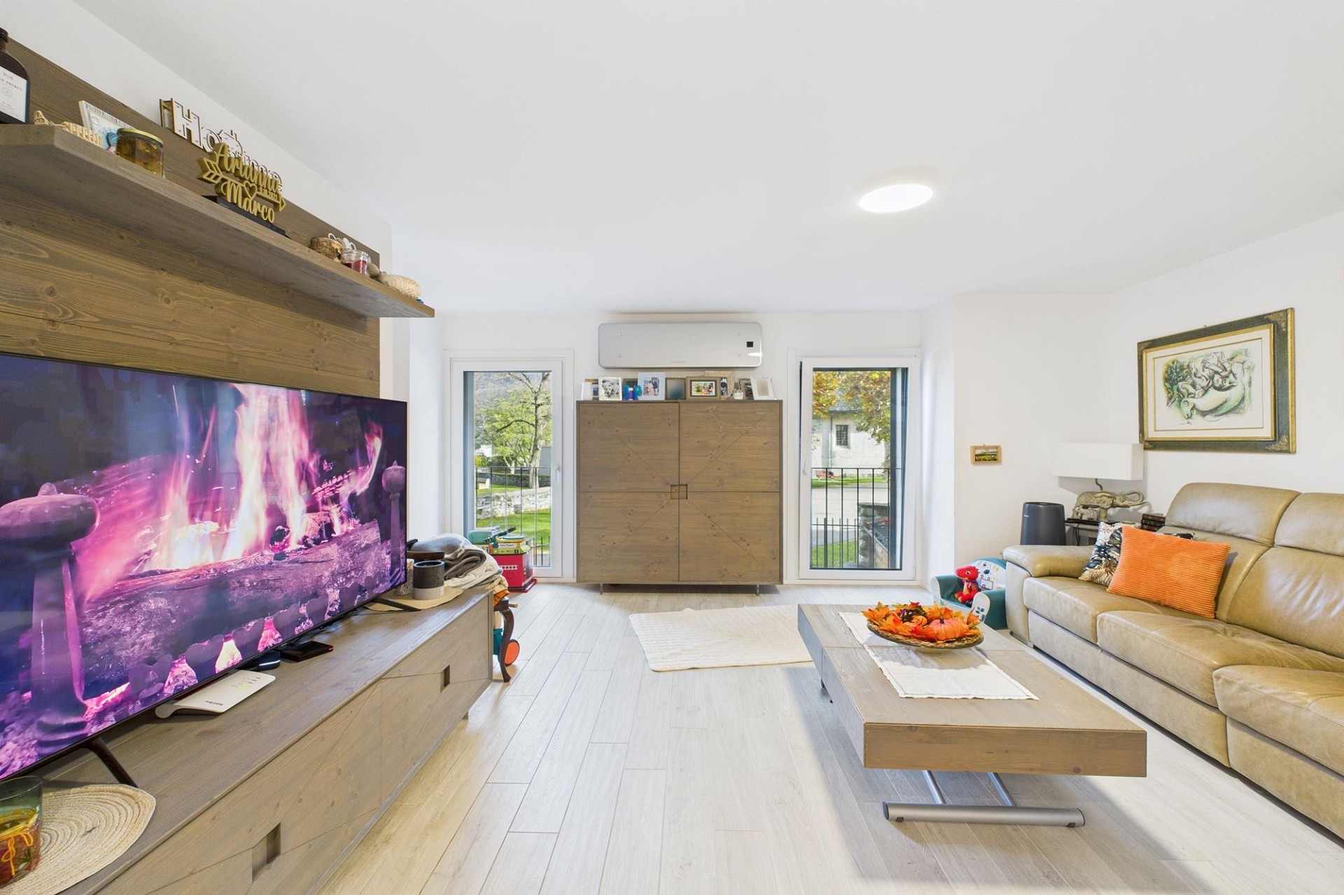 Helles Wohnzimmer mit großer TV-Wand und Sofa