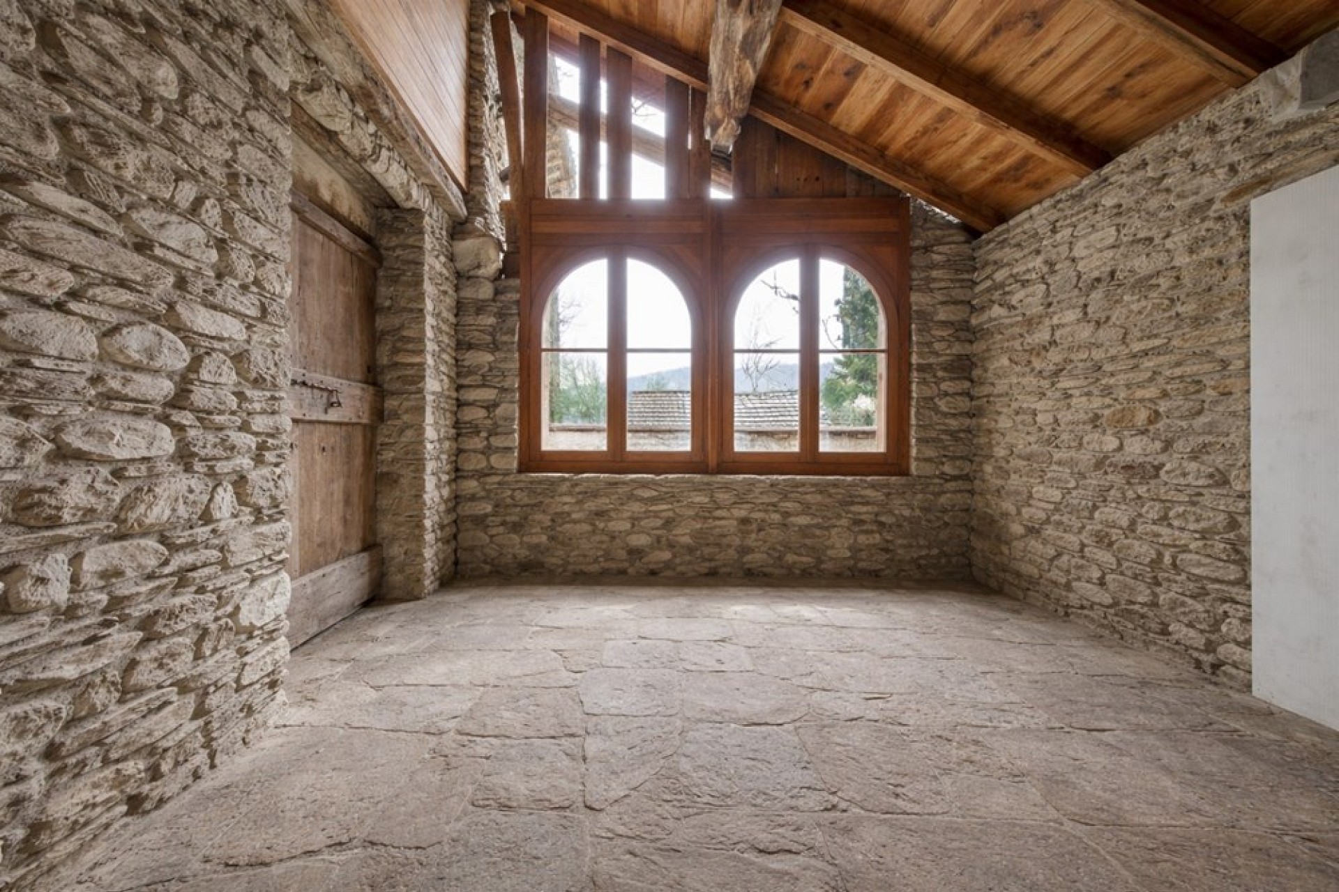 Rustikaler Innenraum mit Steinwänden und Holzdecke