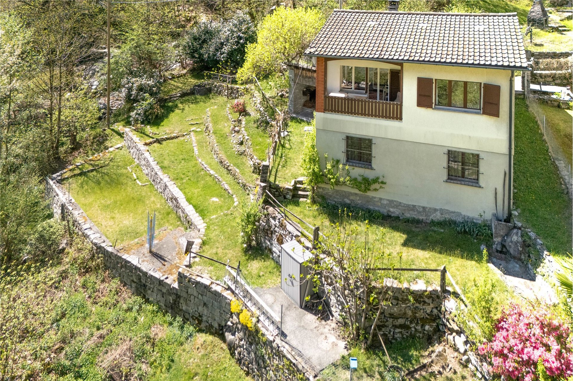 Luftaufnahme eines Hauses mit terrassiertem Garten