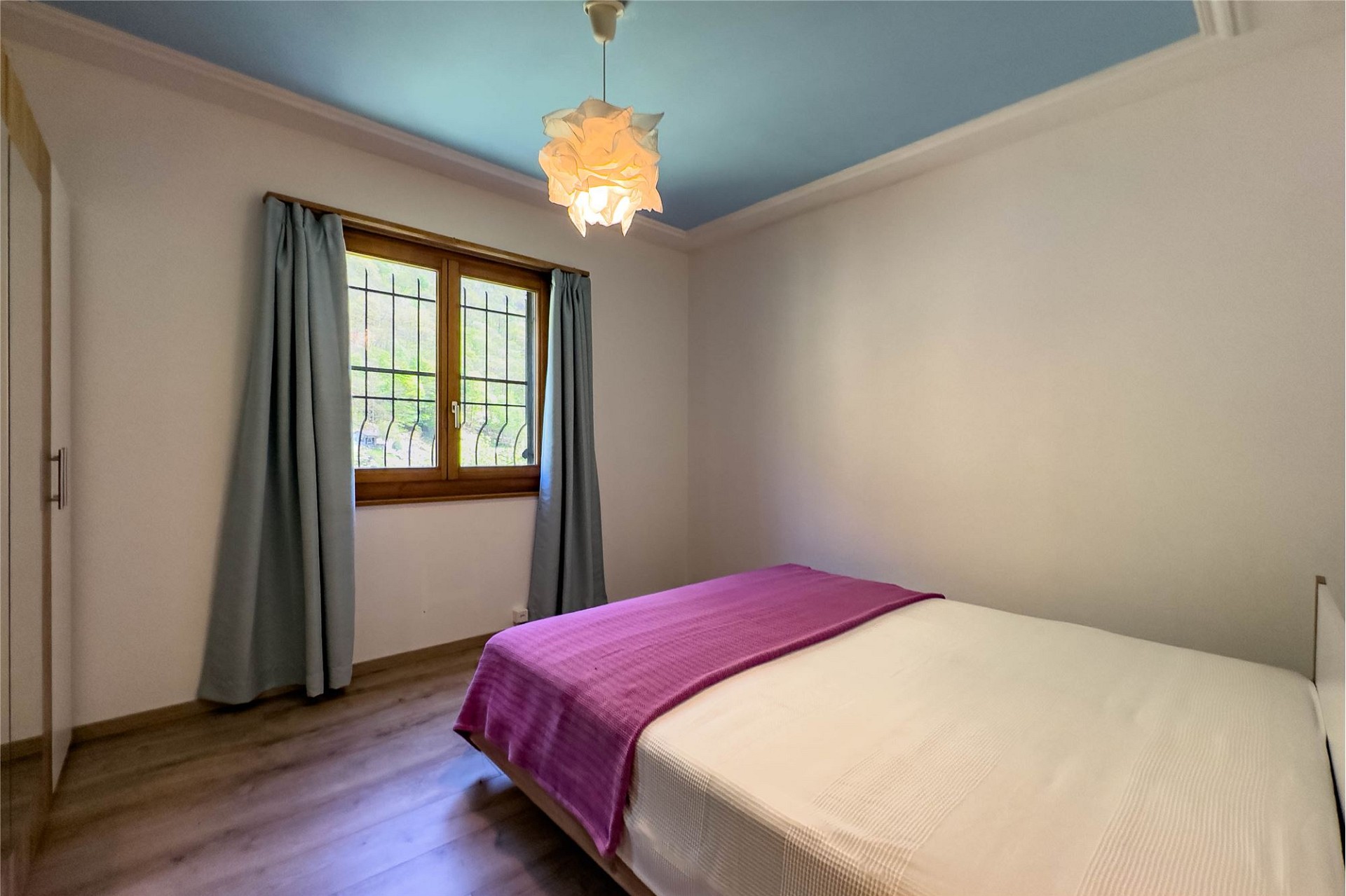 Schlafzimmer mit blau gestrichener Decke