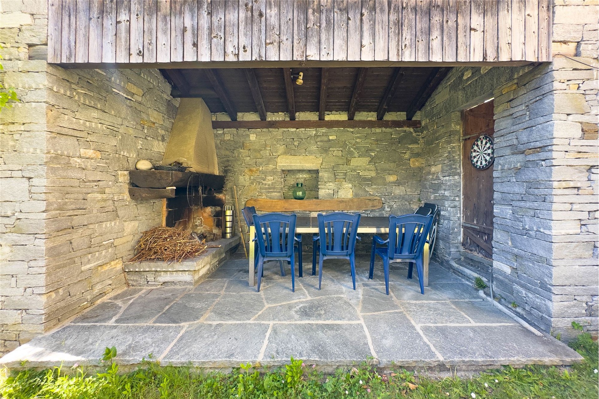 Steinveranda mit Kamin und Sitzbereich