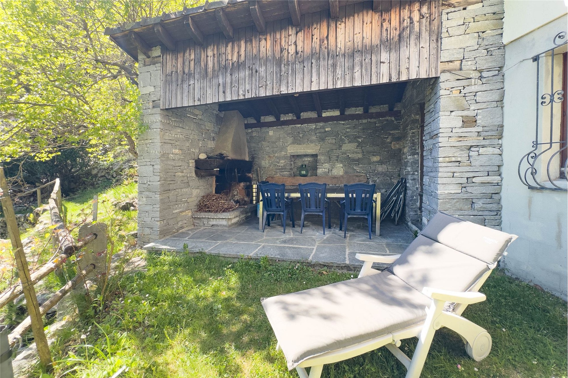 Überdachter Außen-Sitzplatz mit Grill und Gartenliege