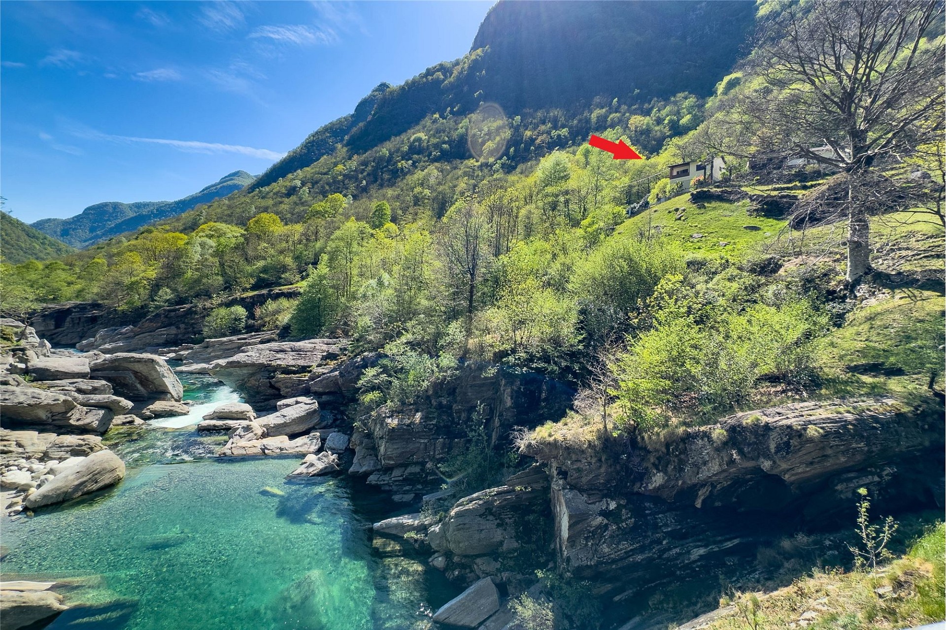 Berglandschaft mit Fluss und kleinem Gebäude