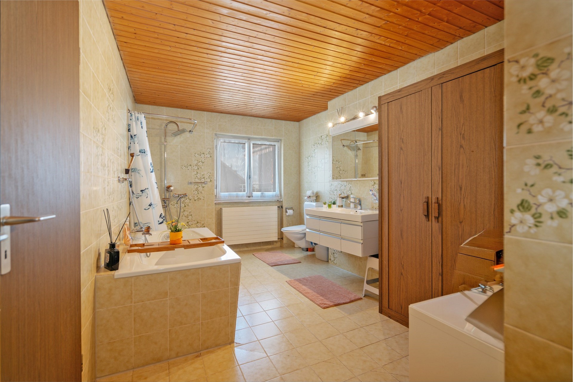 Badezimmer mit Badewanne und Holzdecke
