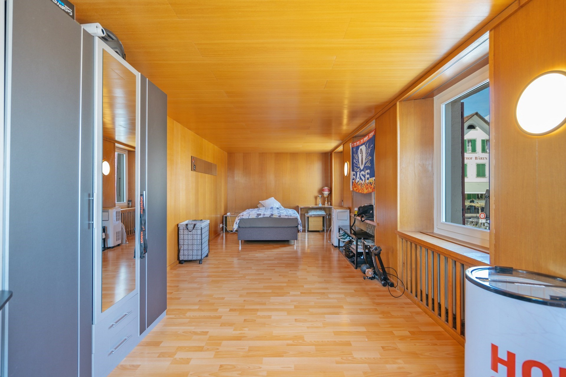 Holzverkleidetes Schlafzimmer mit großem Fenster