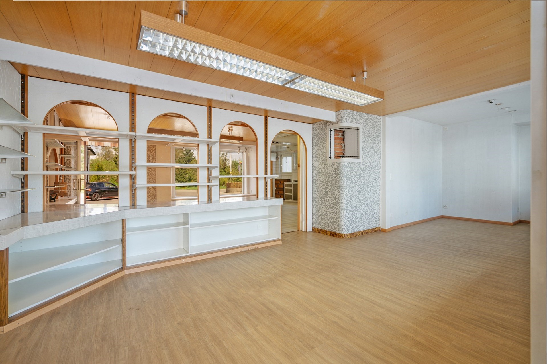 Großer leerer Innenraum mit Holzdecke und Regalen