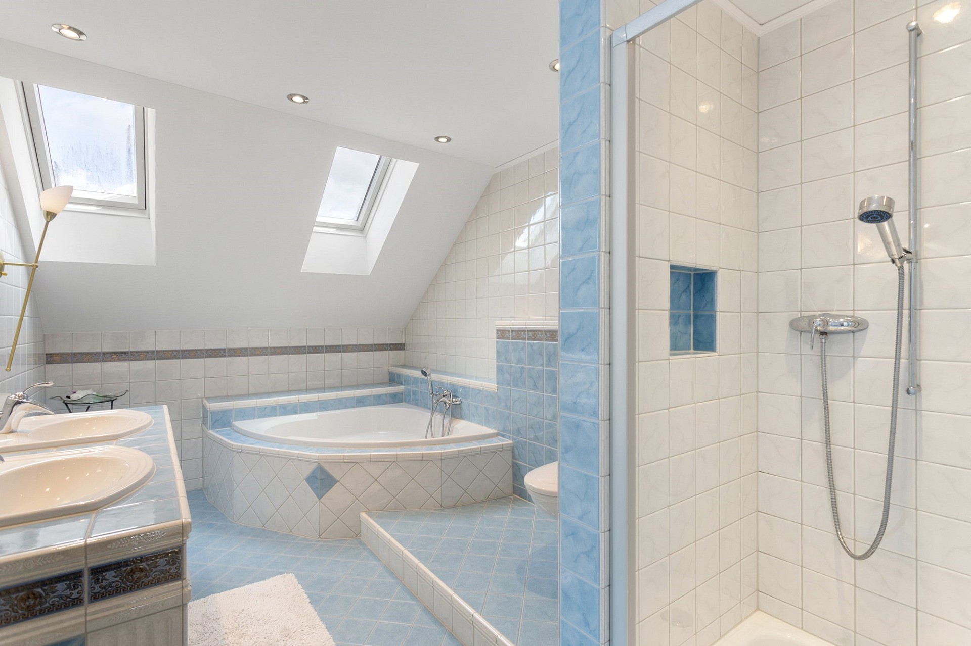 Badezimmer mit Badewanne und Dusche unter Dachschrägen