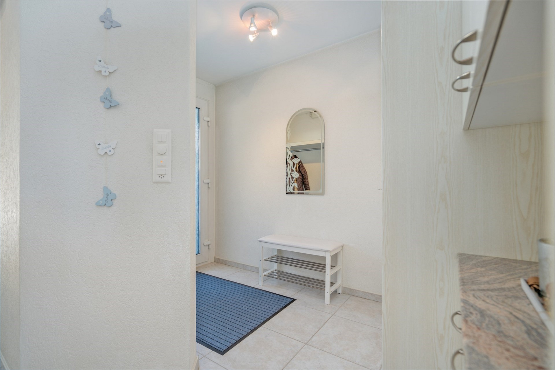 Heller Eingangsbereich mit Fliesenboden und Garderobe
