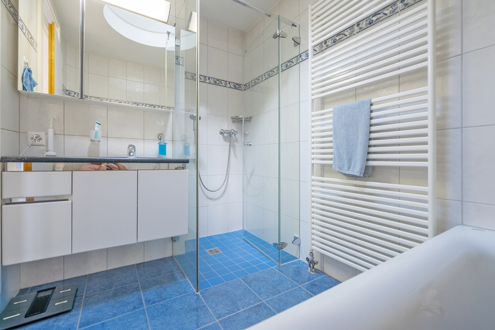 Modernes Badezimmer mit Dusche und blauem Fliesenboden