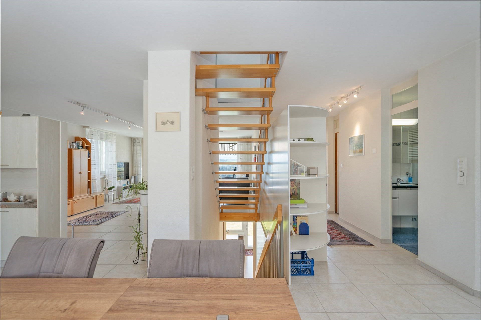 Heller Wohnflur mit Treppe und Blick in angrenzende Räume