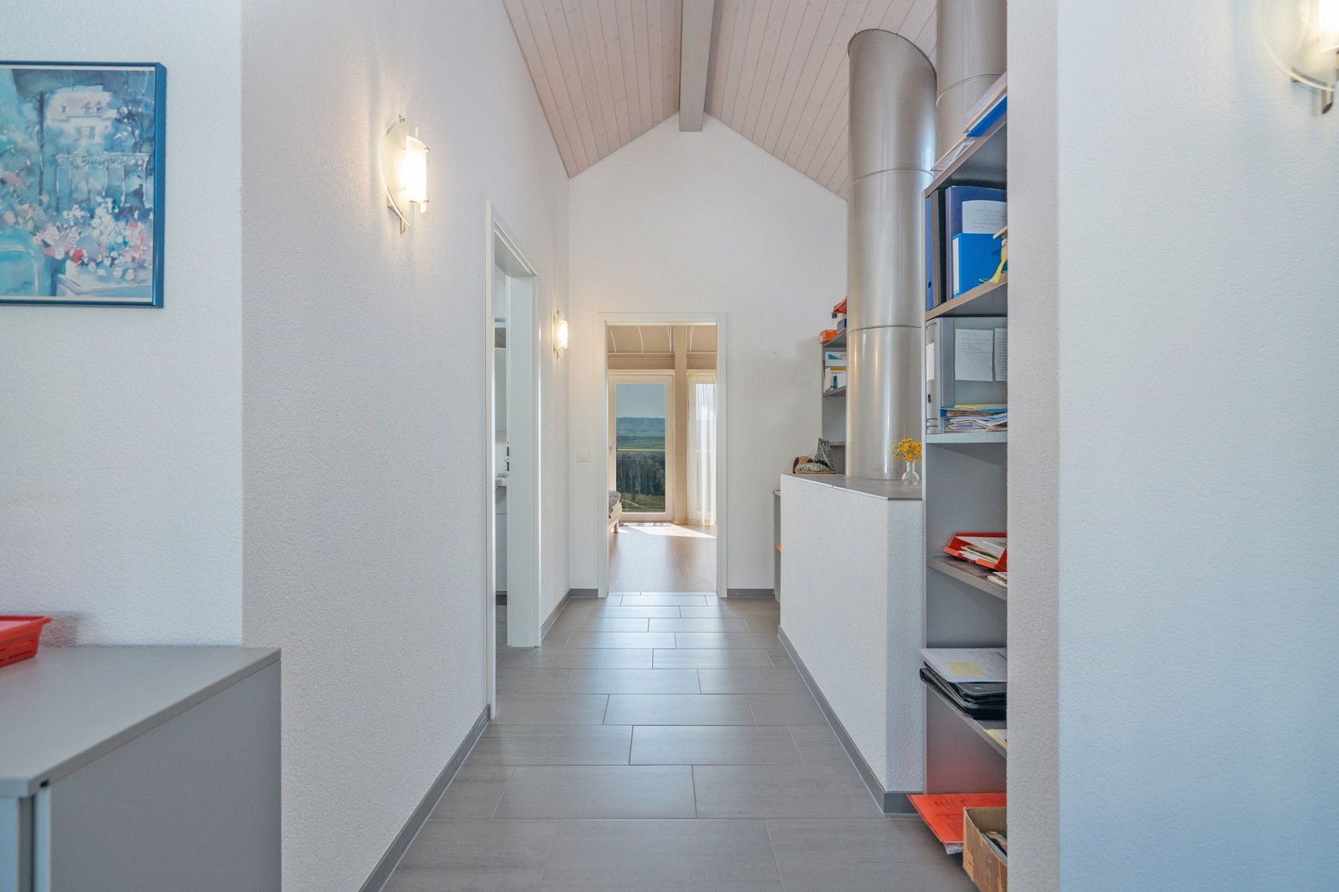Heller Flur mit Dachschräge und Blick ins Wohn-/Esszimmer