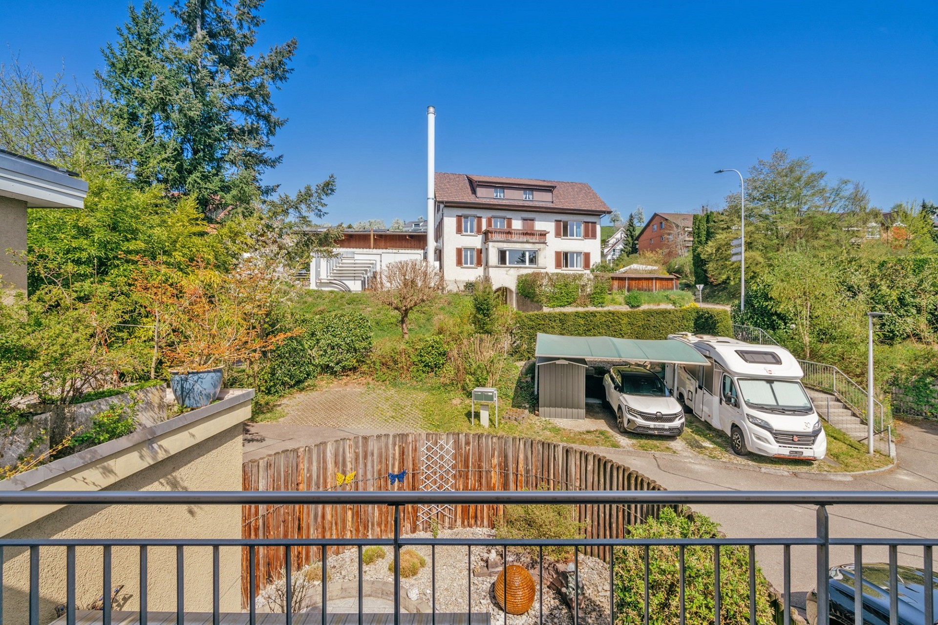Außenansicht eines Wohnhauses mit Garten und Stellplätzen