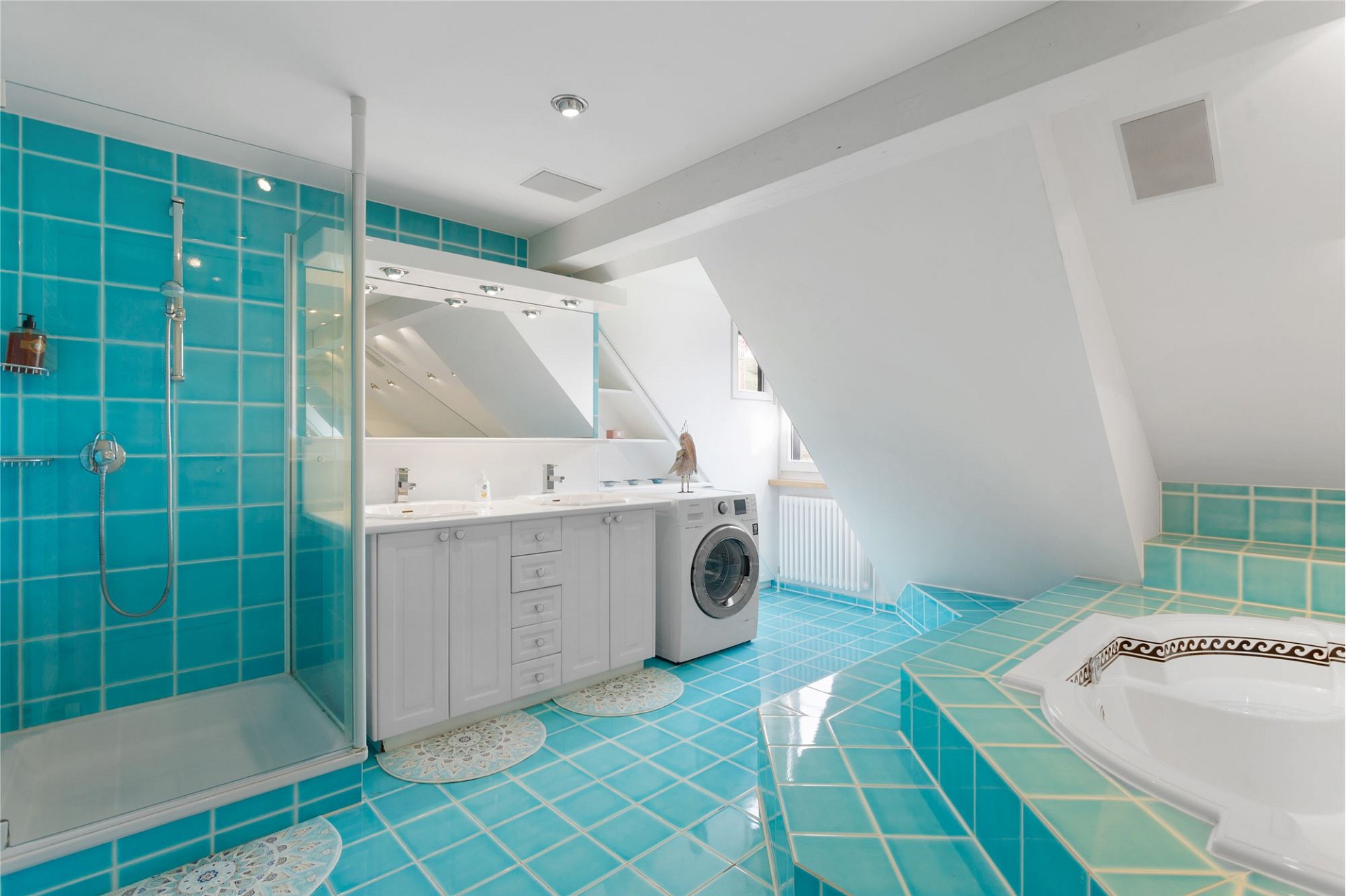 Badezimmer mit türkisfarbenen Fliesen und Dachschräge