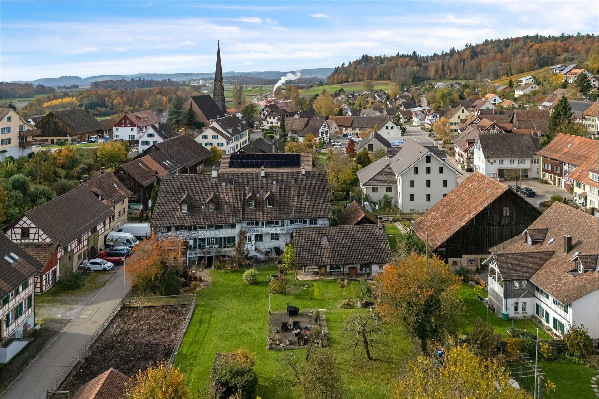 Luftaufnahme eines Dorfes mit Kirchturm und vielen Wohnhäusern