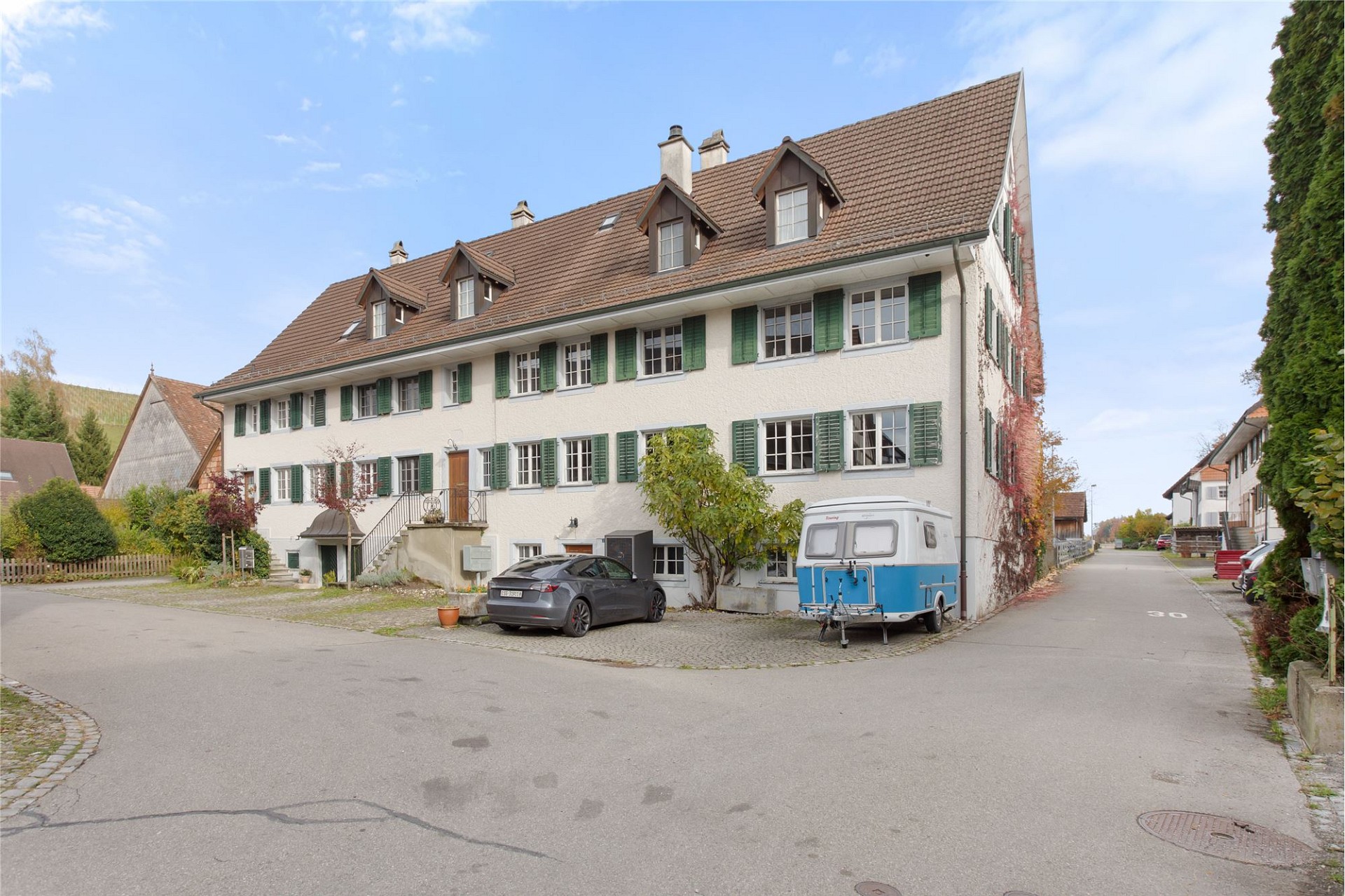 Mehrfamilienhaus mit Satteldach und grünen Fensterläden