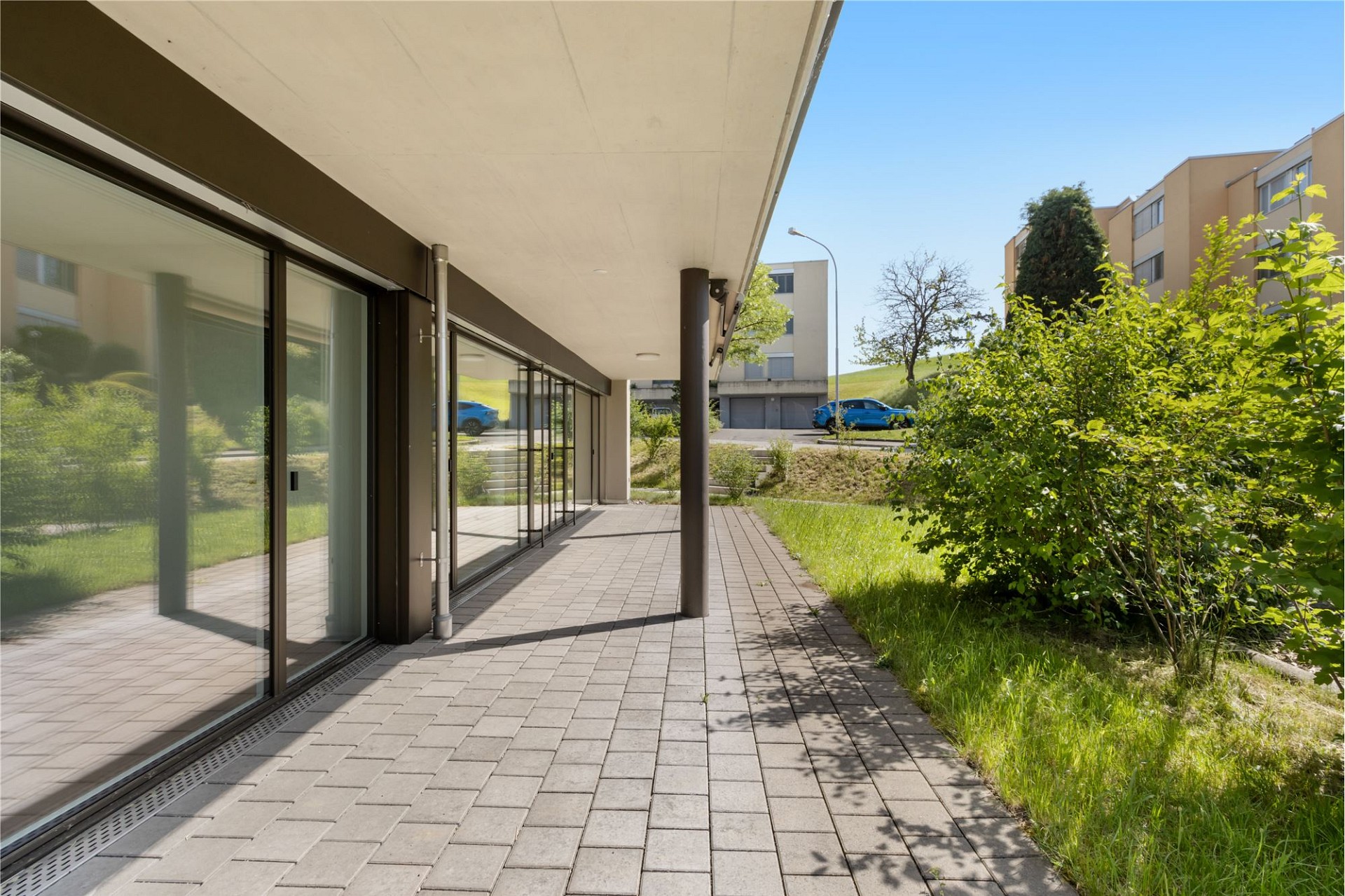 Überdachte Außenansicht mit Terrasse und Grünfläche