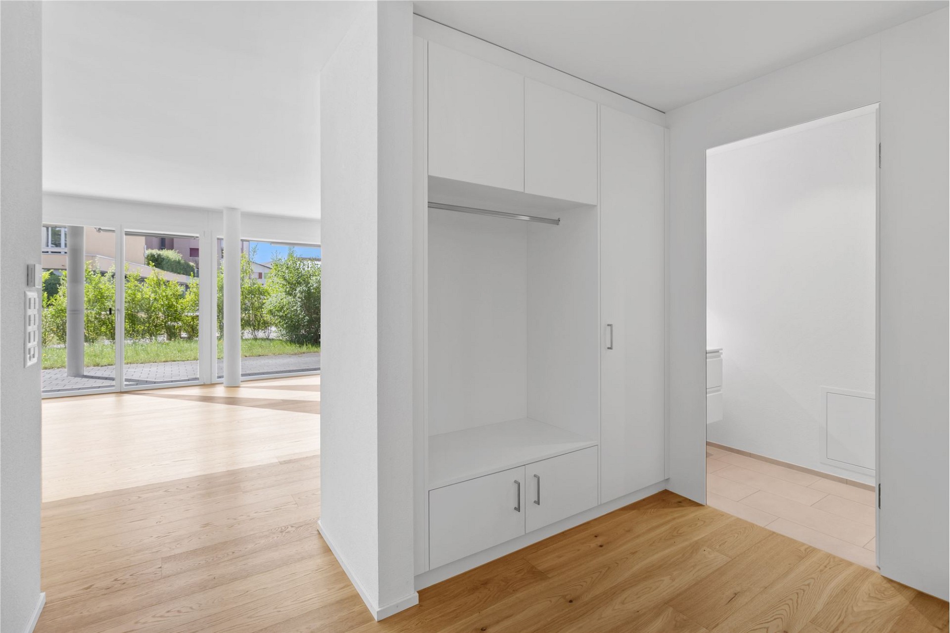 Heller Innenraum mit Einbauschrank und Blick ins Grüne