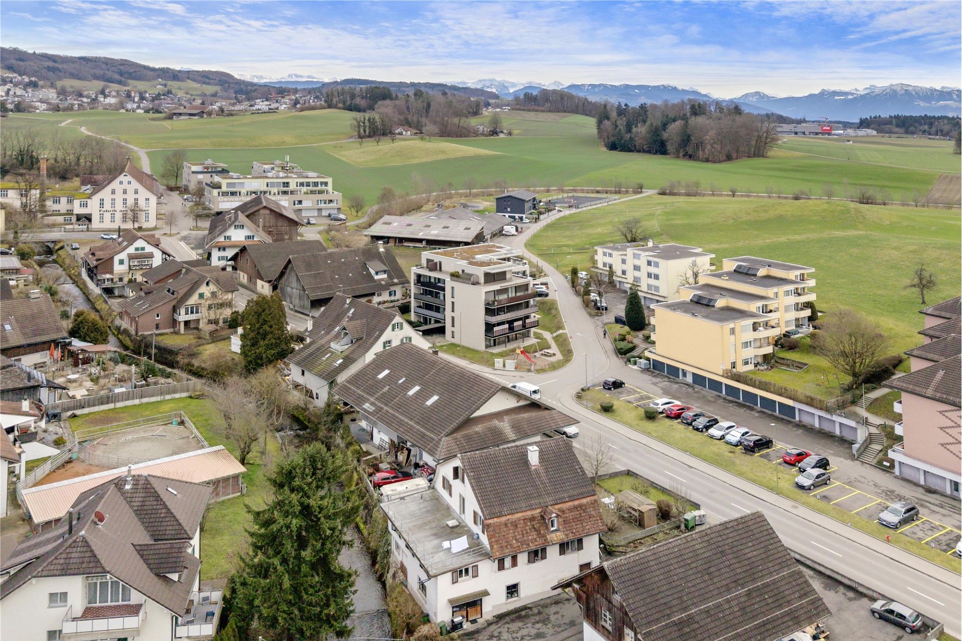 Luftaufnahme eines ländlichen Wohngebiets mit Bergen