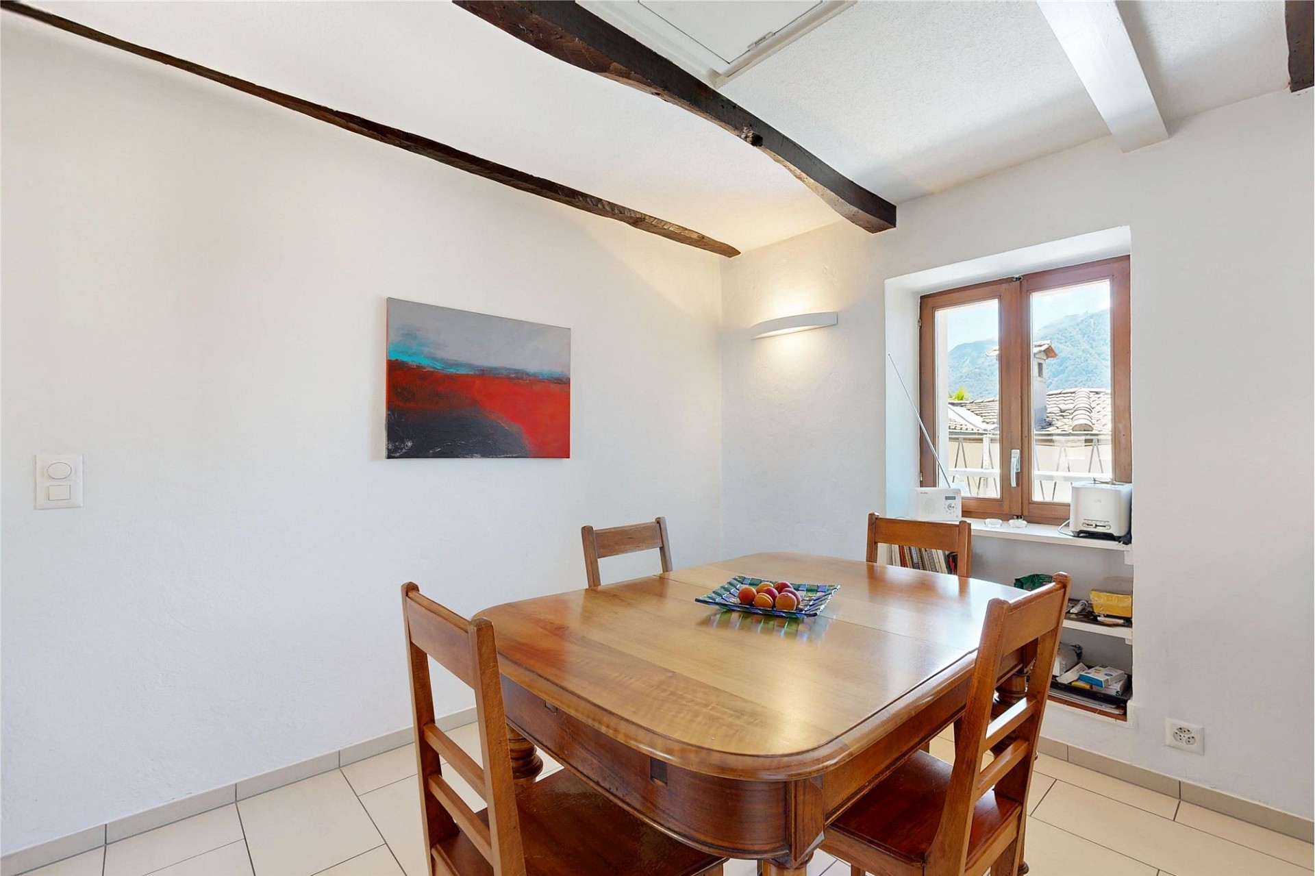 Esszimmer mit Holztisch und Blick ins Gebirge