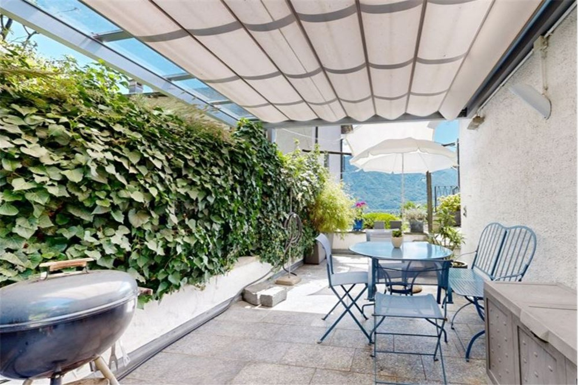 Überdachte Dachterrasse mit Sitzplatz und Blick ins Grüne