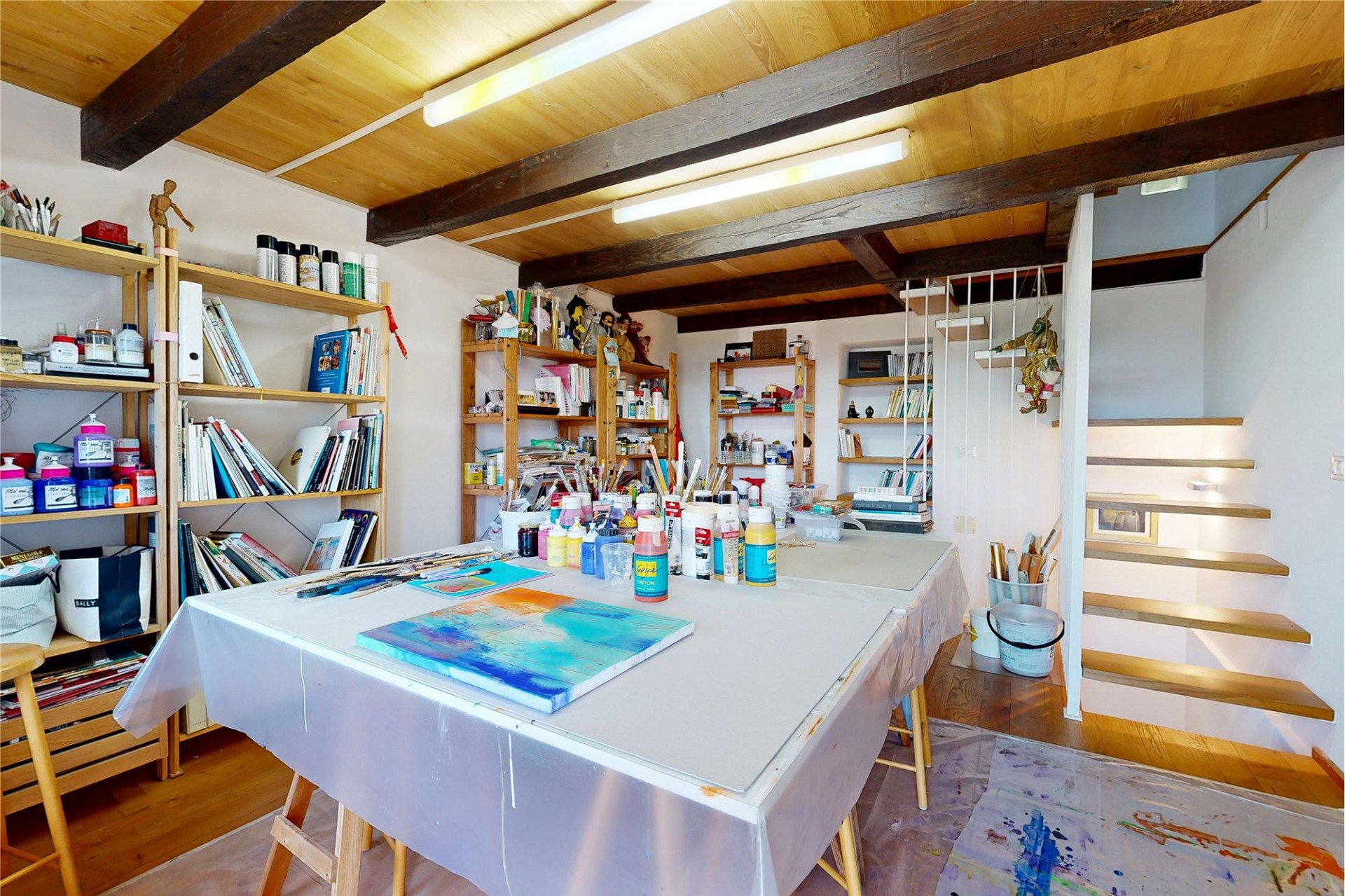 Atelierraum mit Arbeitsfläche und Regalen