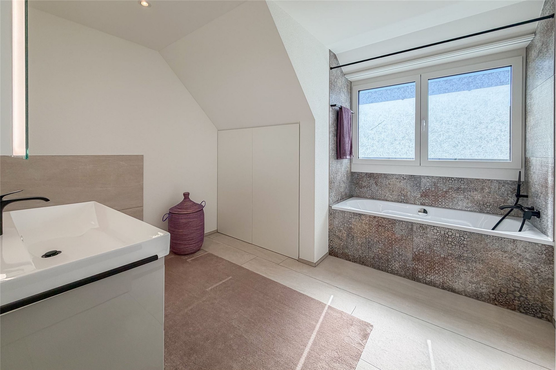 Helles, modernes Badezimmer mit Wanne und Dachfenster