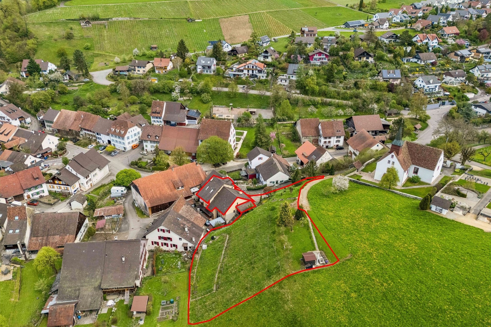 Luftaufnahme eines ländlichen Wohngebiets mit markiertem Grundstück