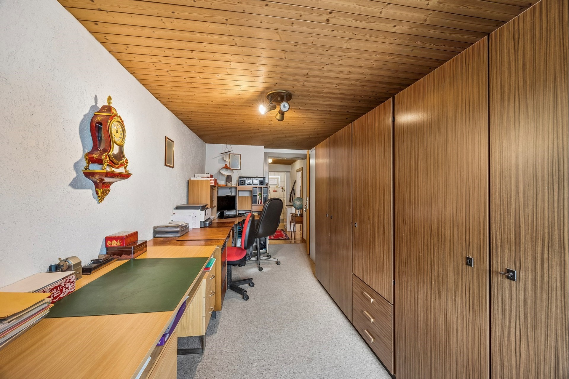 Schmaler Arbeitsraum mit viel Holz und Einbauschränken