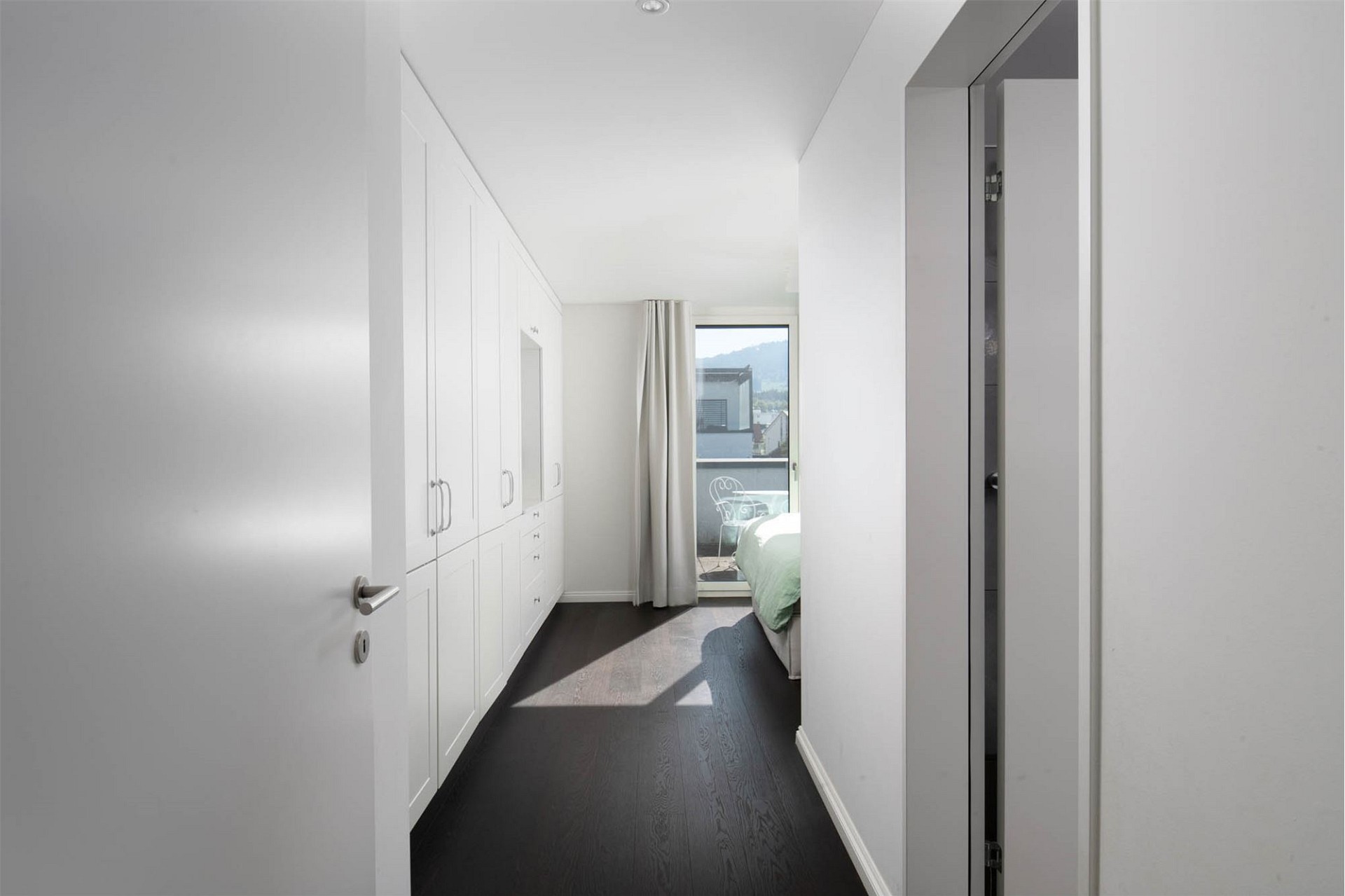 Helles Schlafzimmer mit Einbauschrank und Balkonblick