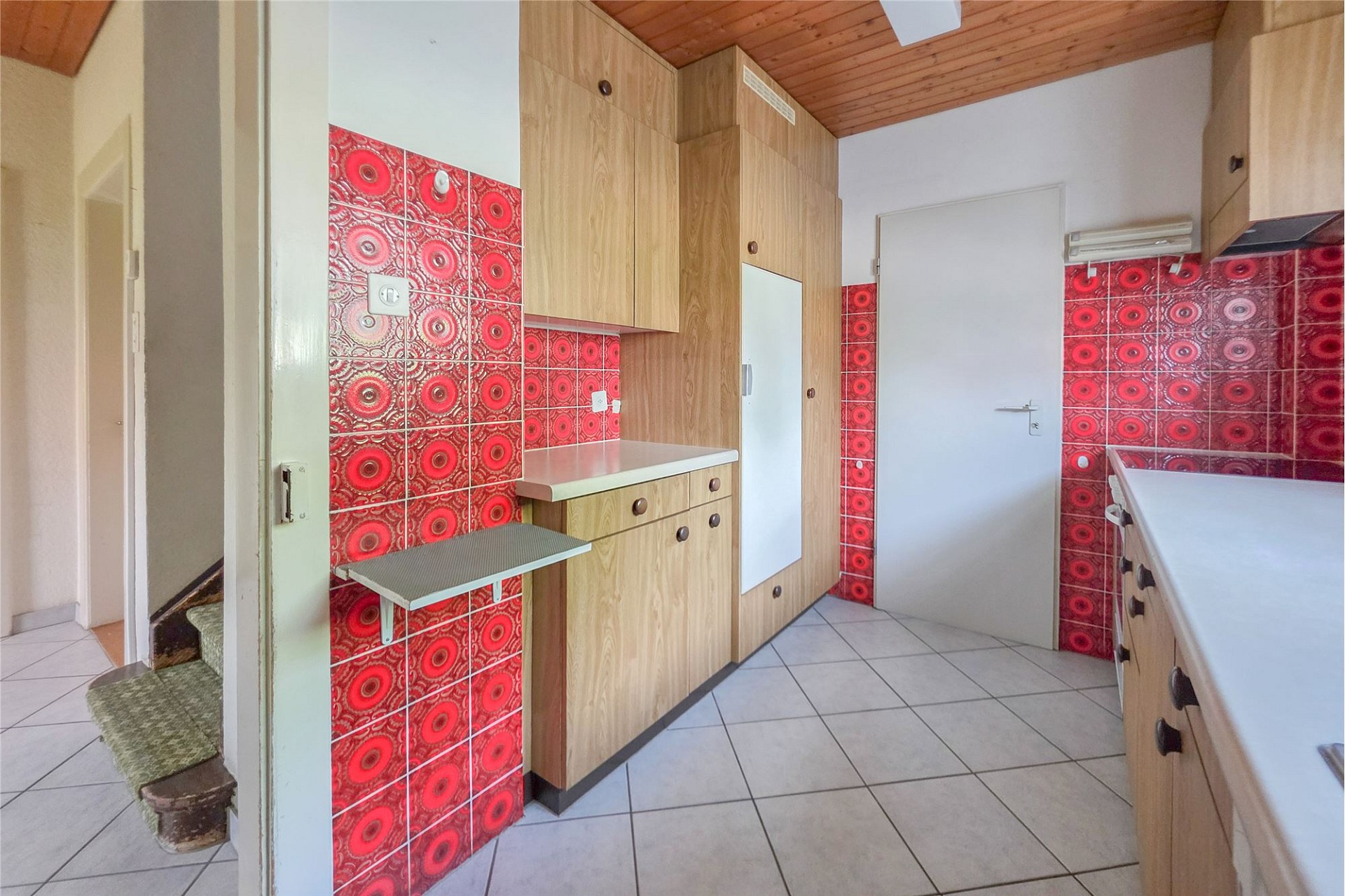 Bunte Küche mit roten Fliesen und Holzschränken