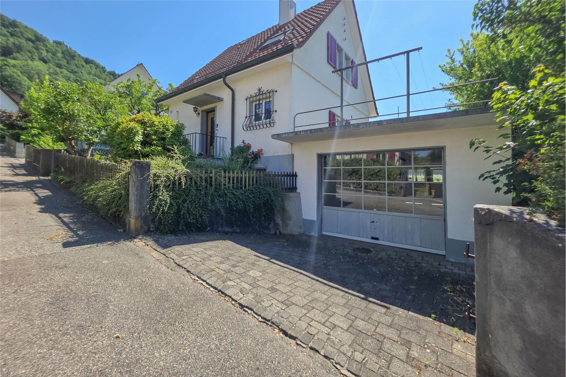 Hausansicht mit Garage und Garten