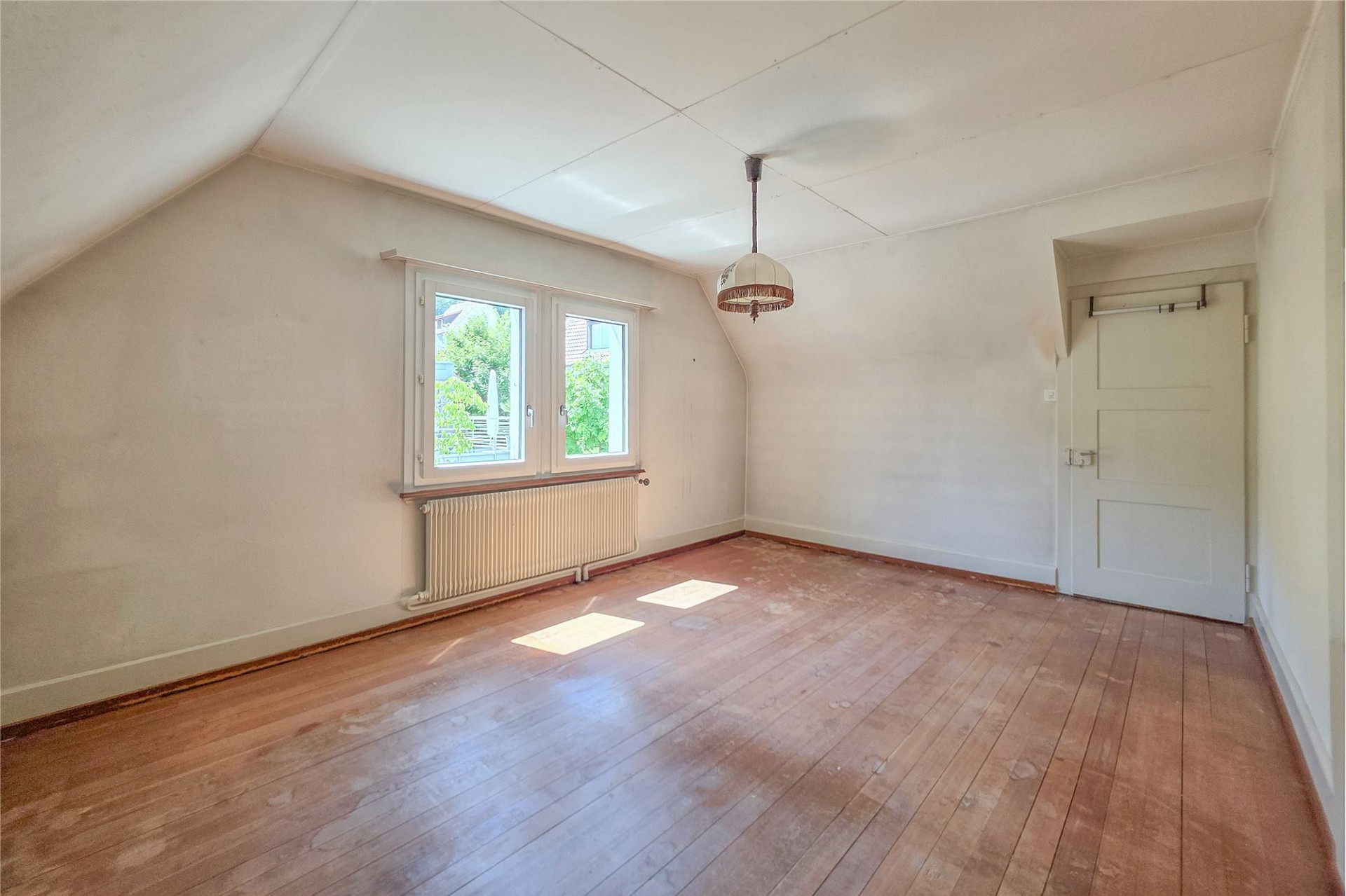Leerer Dachraum mit Fenster und Tür