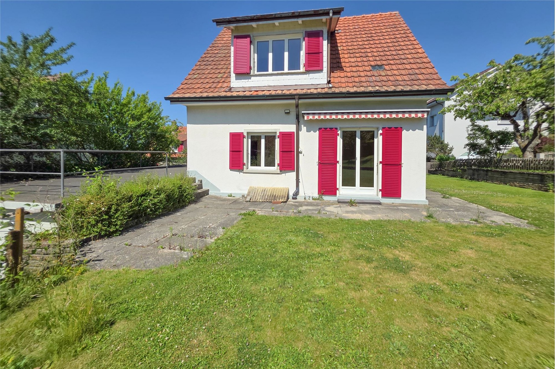 Einfamilienhaus mit rotem Ziegeldach und Garten