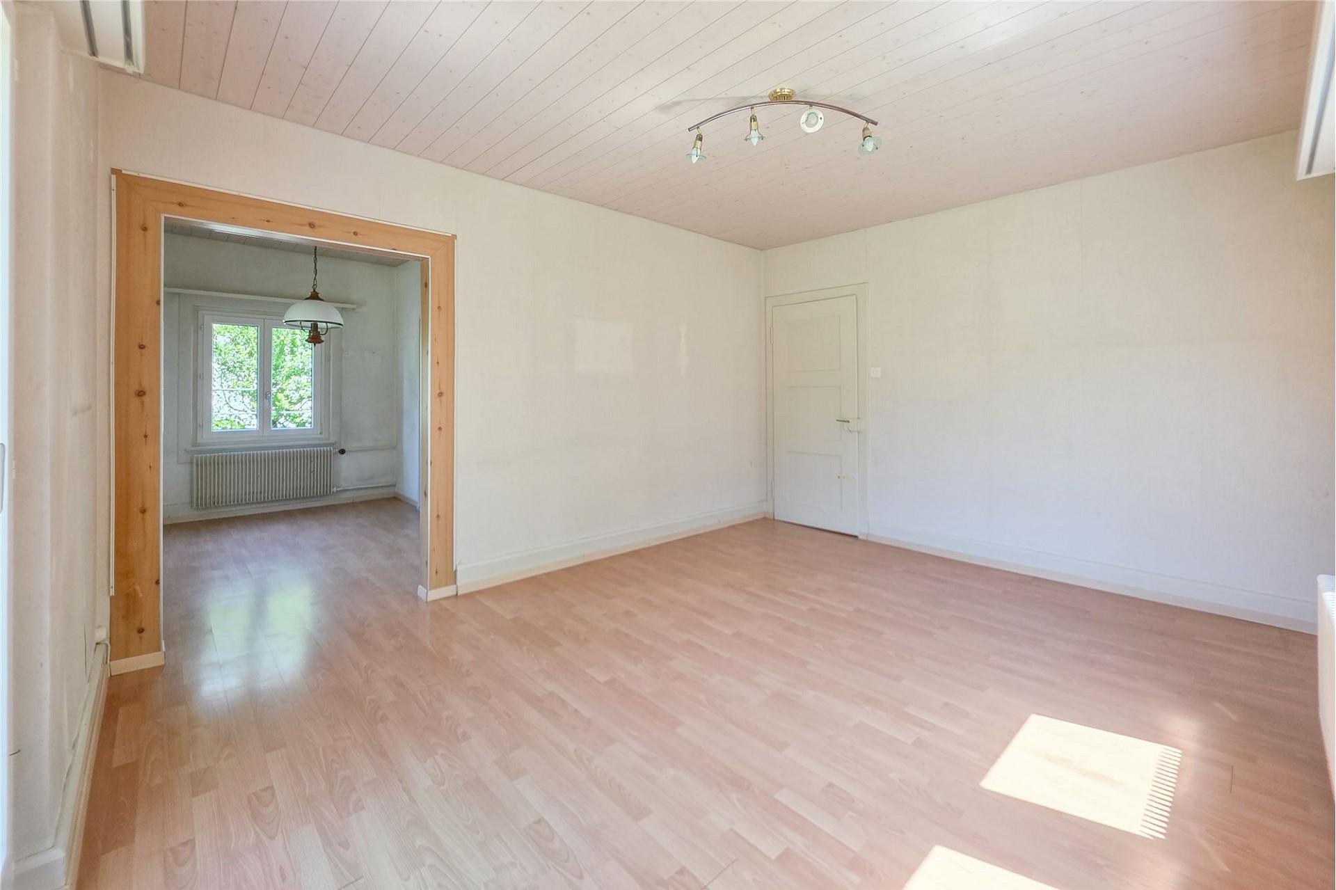 Leeres Zimmer mit Holzboden und Durchgang